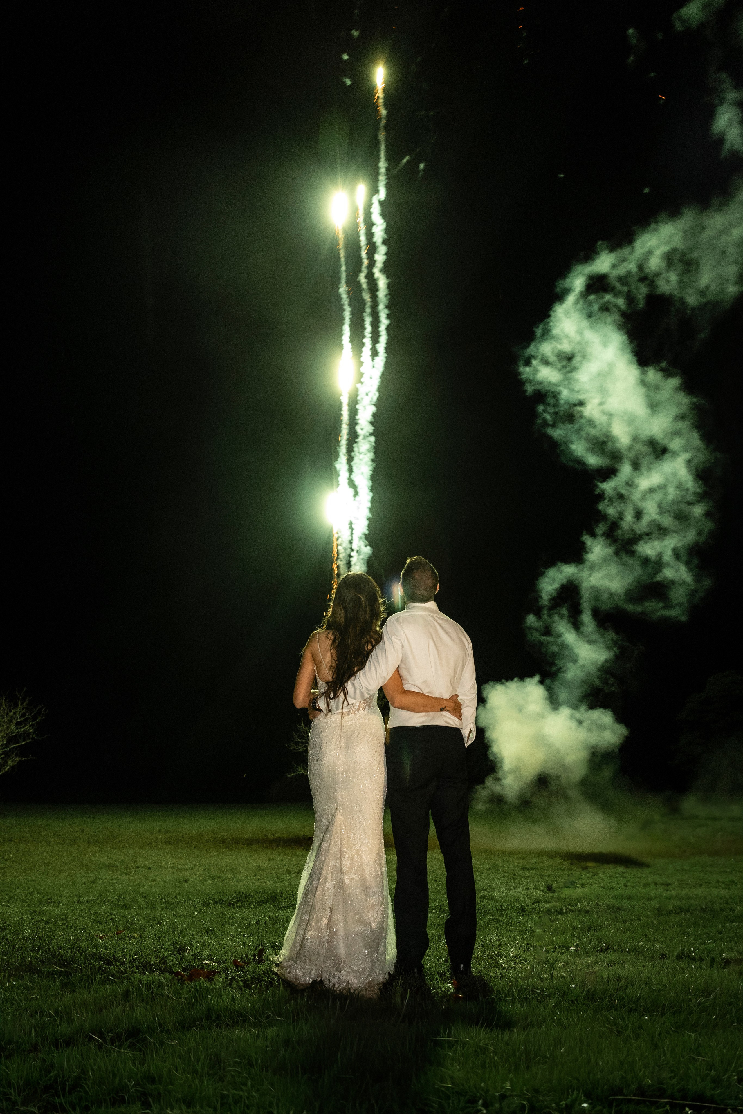 Bride and groom watching fireworks in the courtyard of Château Lagut, Dordogne.
