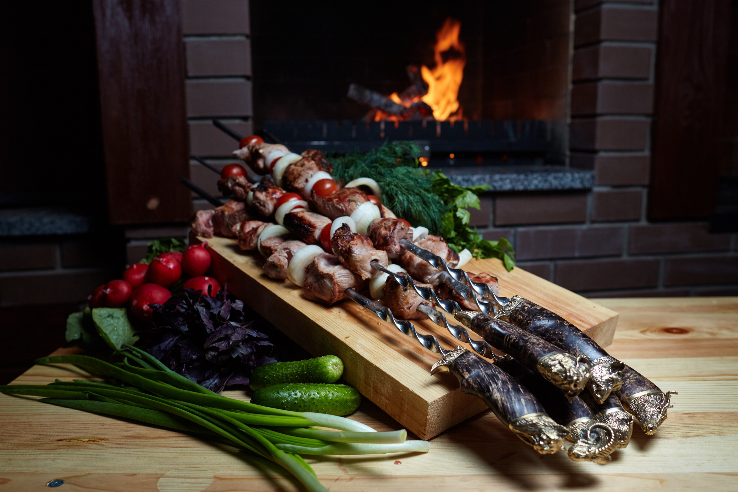 Brochettes grillées servies sur planche en bois avec herbes fraîches devant une cheminée – photographie culinaire professionnelle