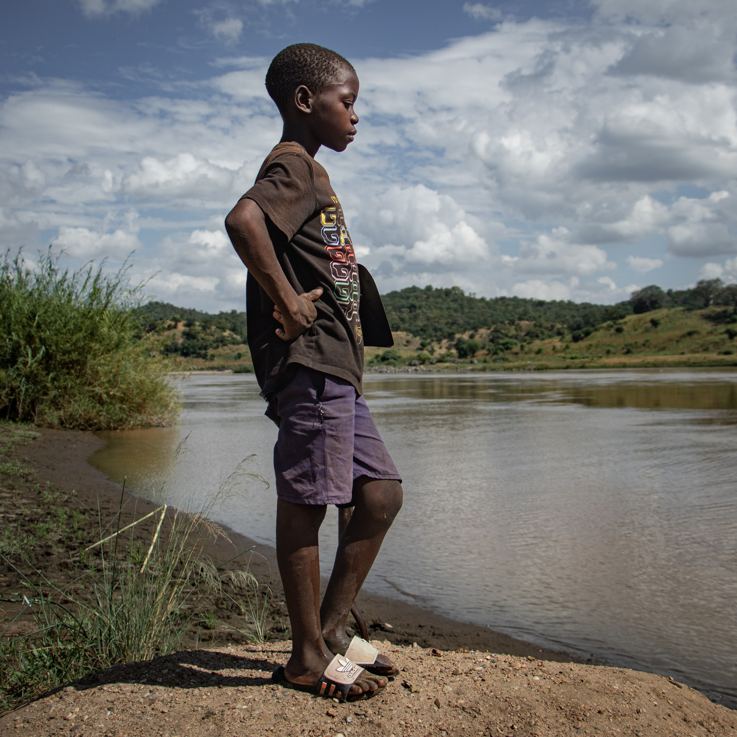 Un enfant du village, symbole d’une jeunesse grandissant dans l’incertitude. Dans cette région rurale menacée par le projet de méga barrage de Mphanda Nkuwa, des milliers d’enfants vivent sur des terres ancestrales sans savoir si elles seront demain submergées ou interdites d’accès. L’enfance ici se mêle à la crainte silencieuse d’un déracinement à venir. Une génération qui risque de voir son avenir compromis.