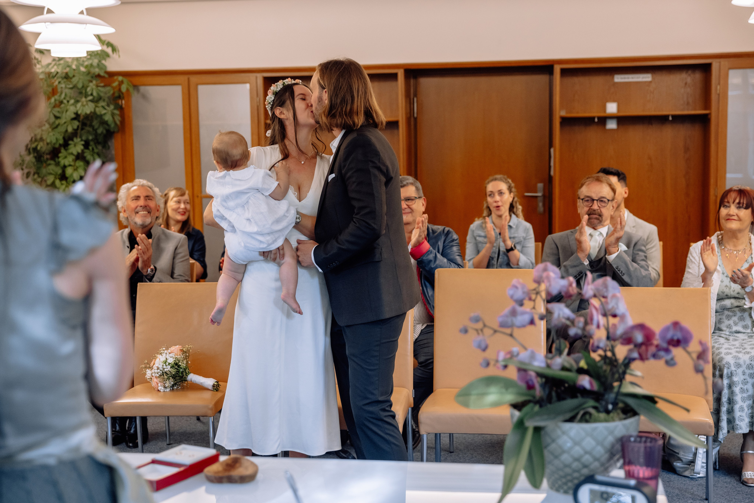 Gäste applaudieren nach dem Ja-Wort – Brautpaar mit Baby im Vordergrund, Standesamt Schwabing