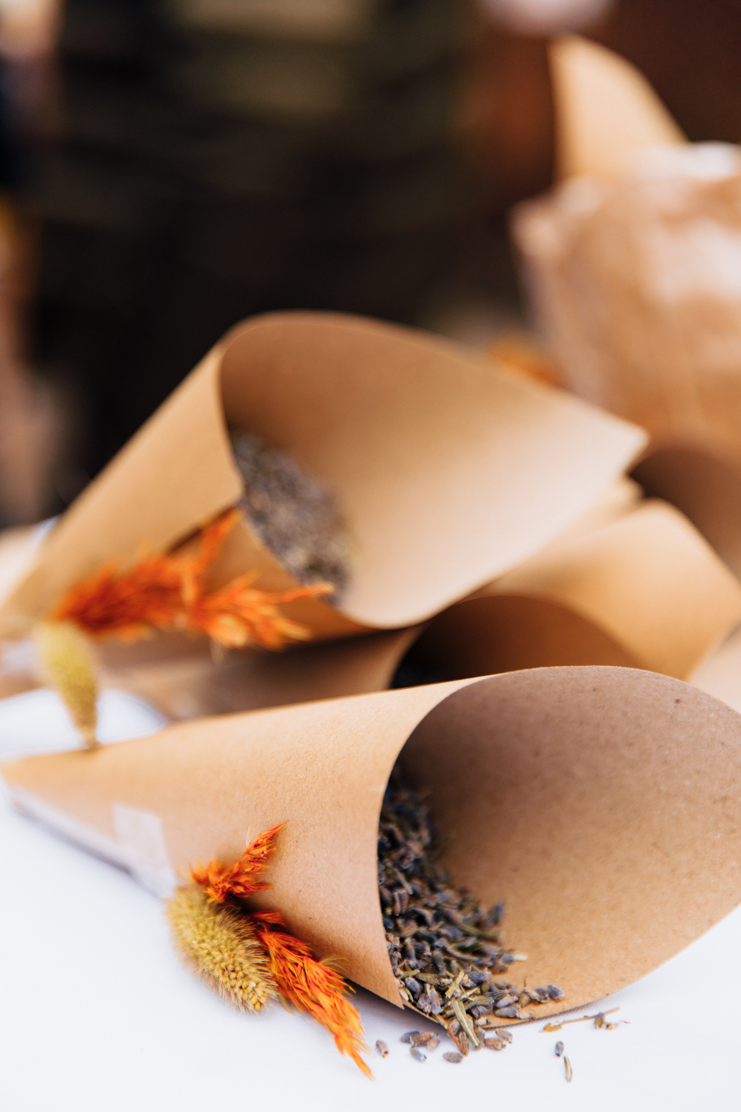 Zwei Umschläge aus Kraftpapier, verziert mit getrockneten Blumen und gefüllt mit getrocknetem Lavendel.