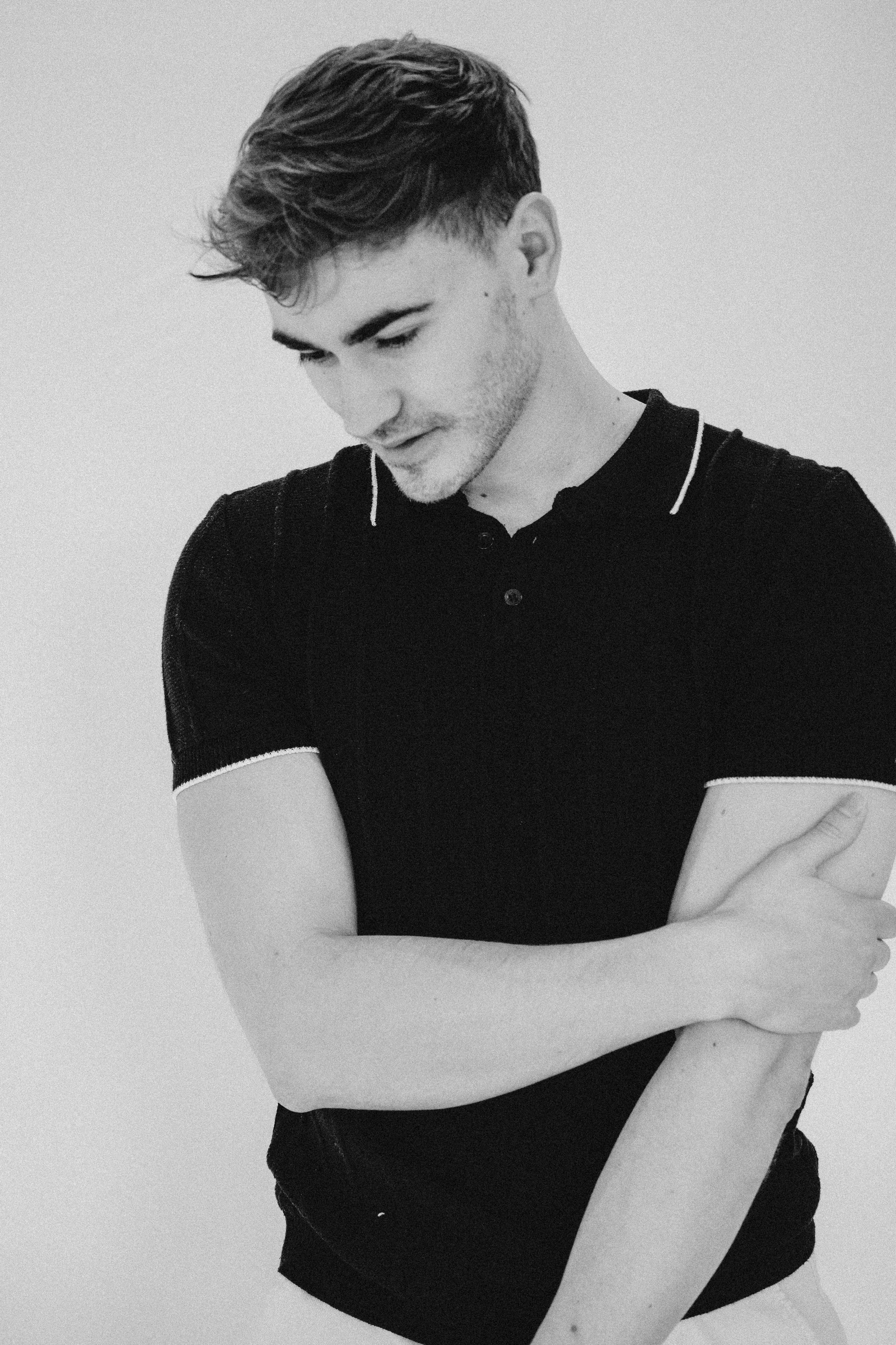 Minimalist test shoot of male model in monochrome outfit, posing confidently in studio lighting