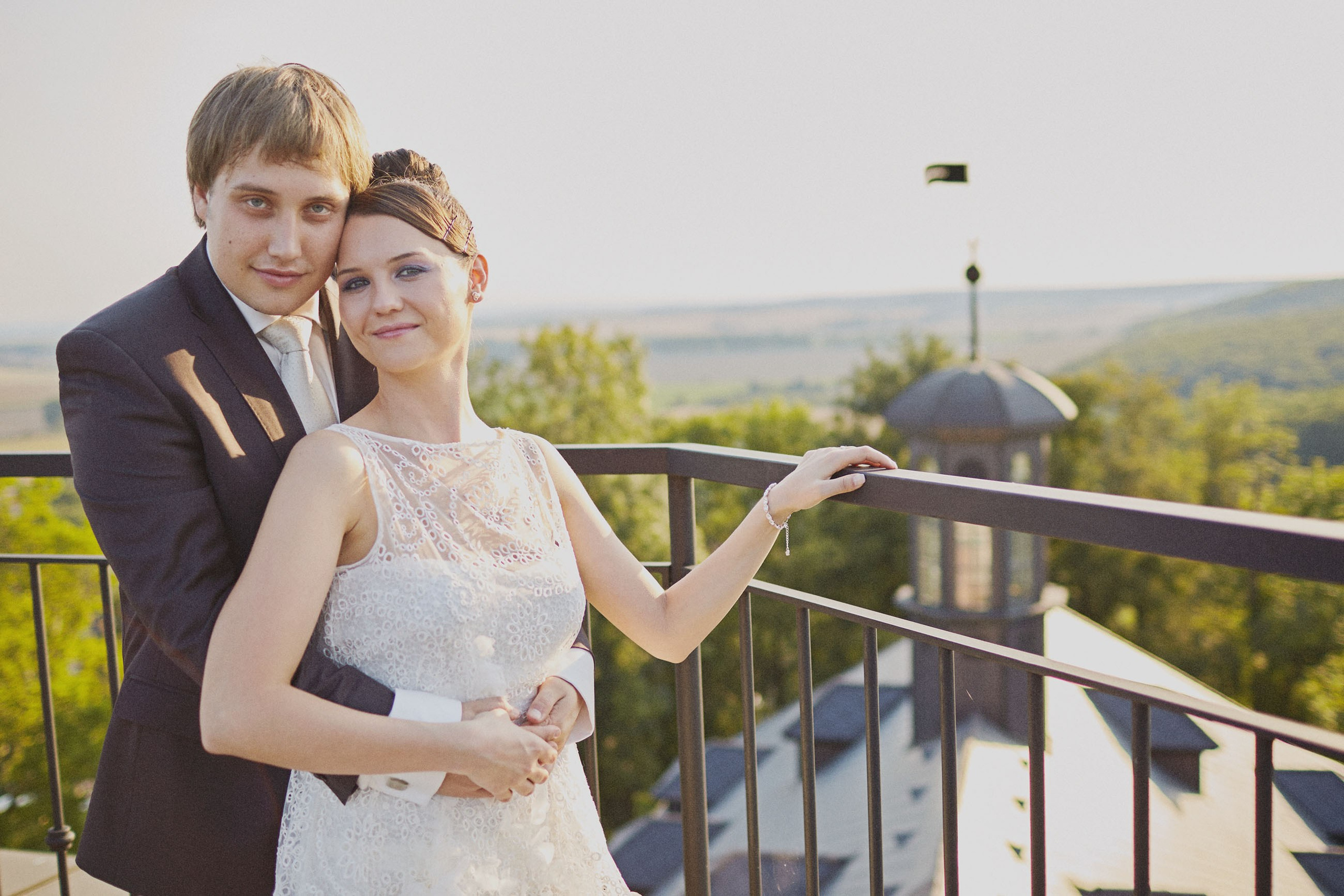 Celebrate the joy of the wedding journey with this radiant, brown-haired bride, beaming with happiness as she's prepared at a historic chateauYoung bride in short wedding dress looking out window at Chateau Mcely.