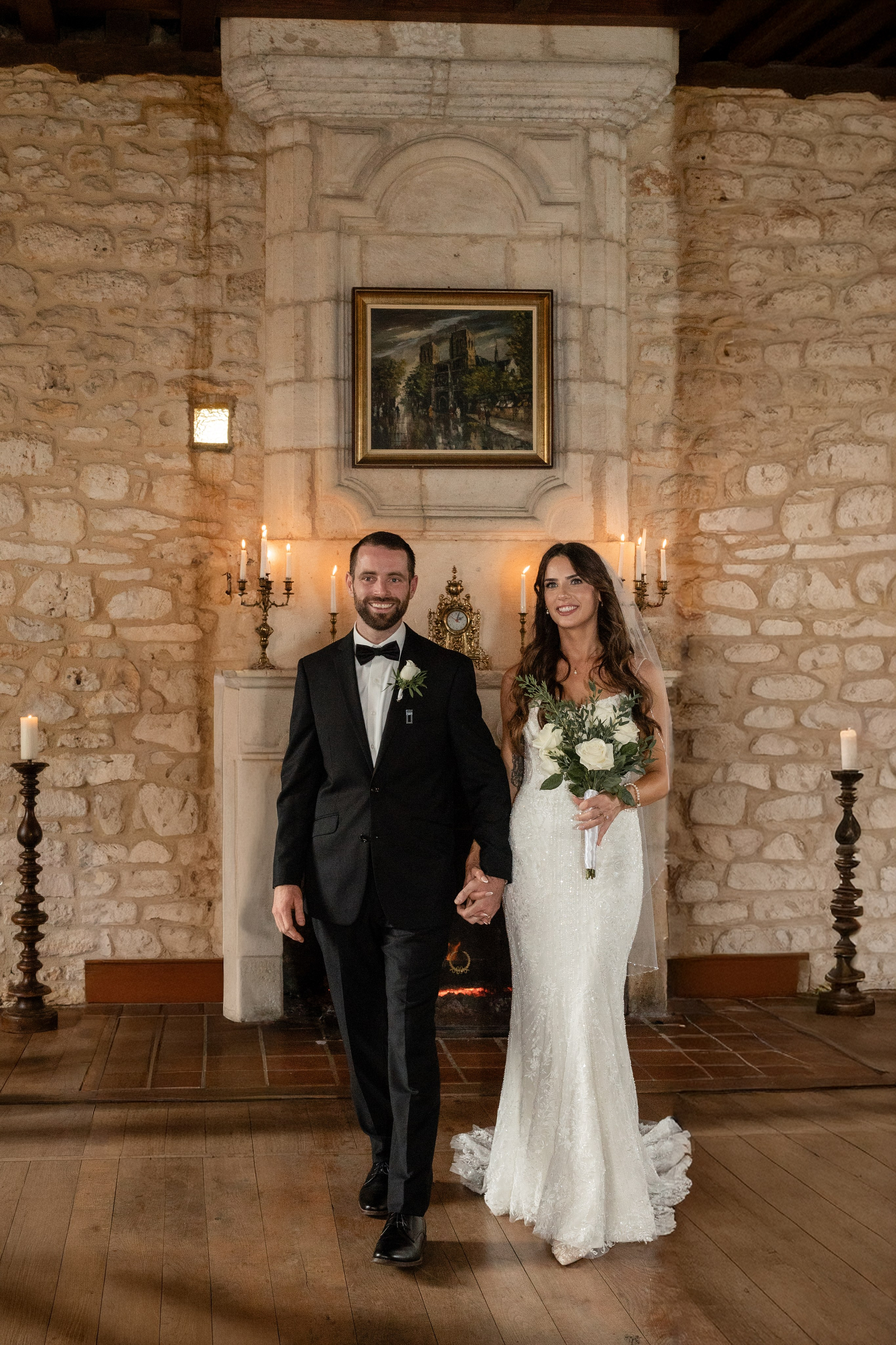 Indoor wedding ceremony at Château Lagut with candlelight and fireplace backdrop.