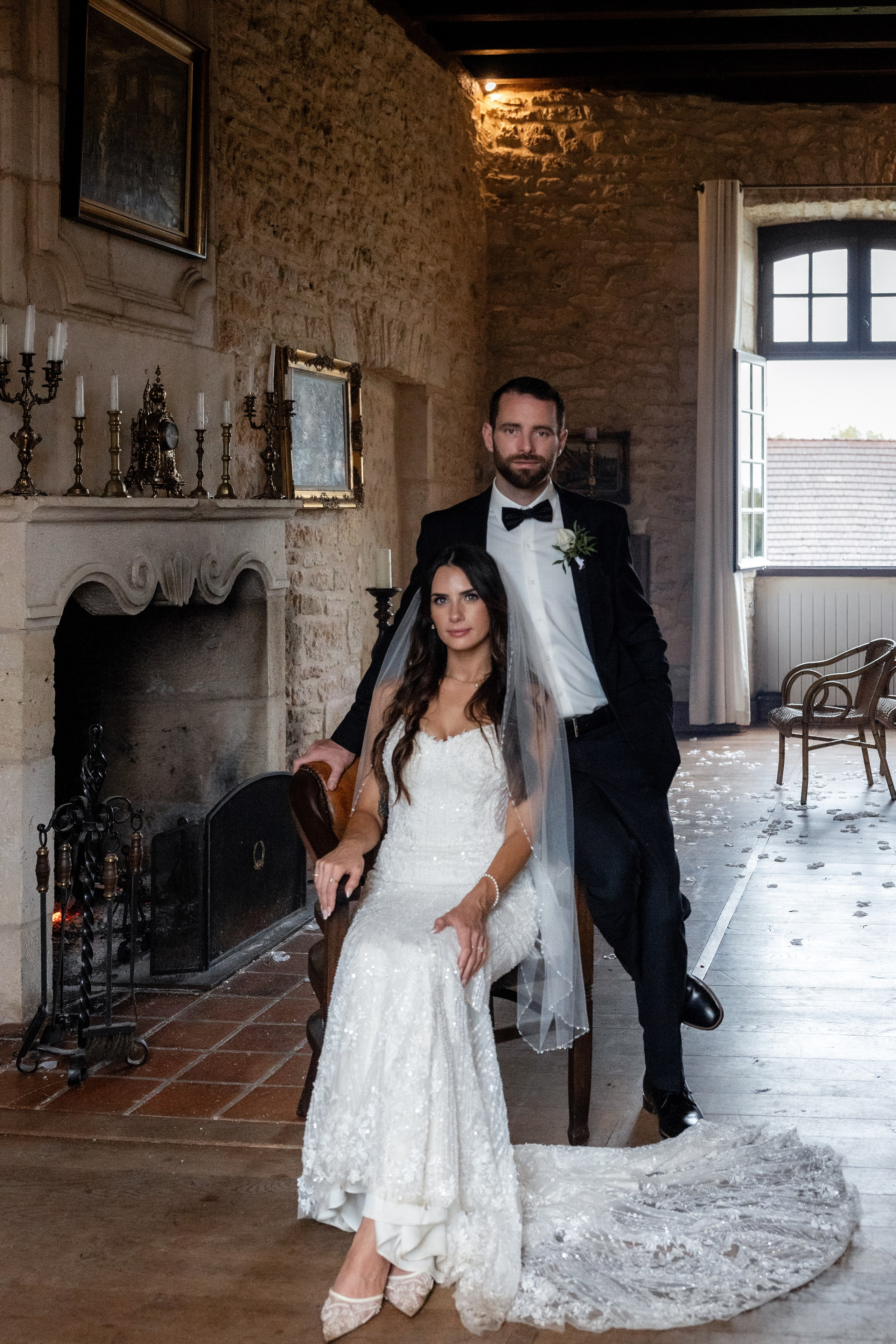 Editorial-style couple portrait with château window light in Dordogne, France.
