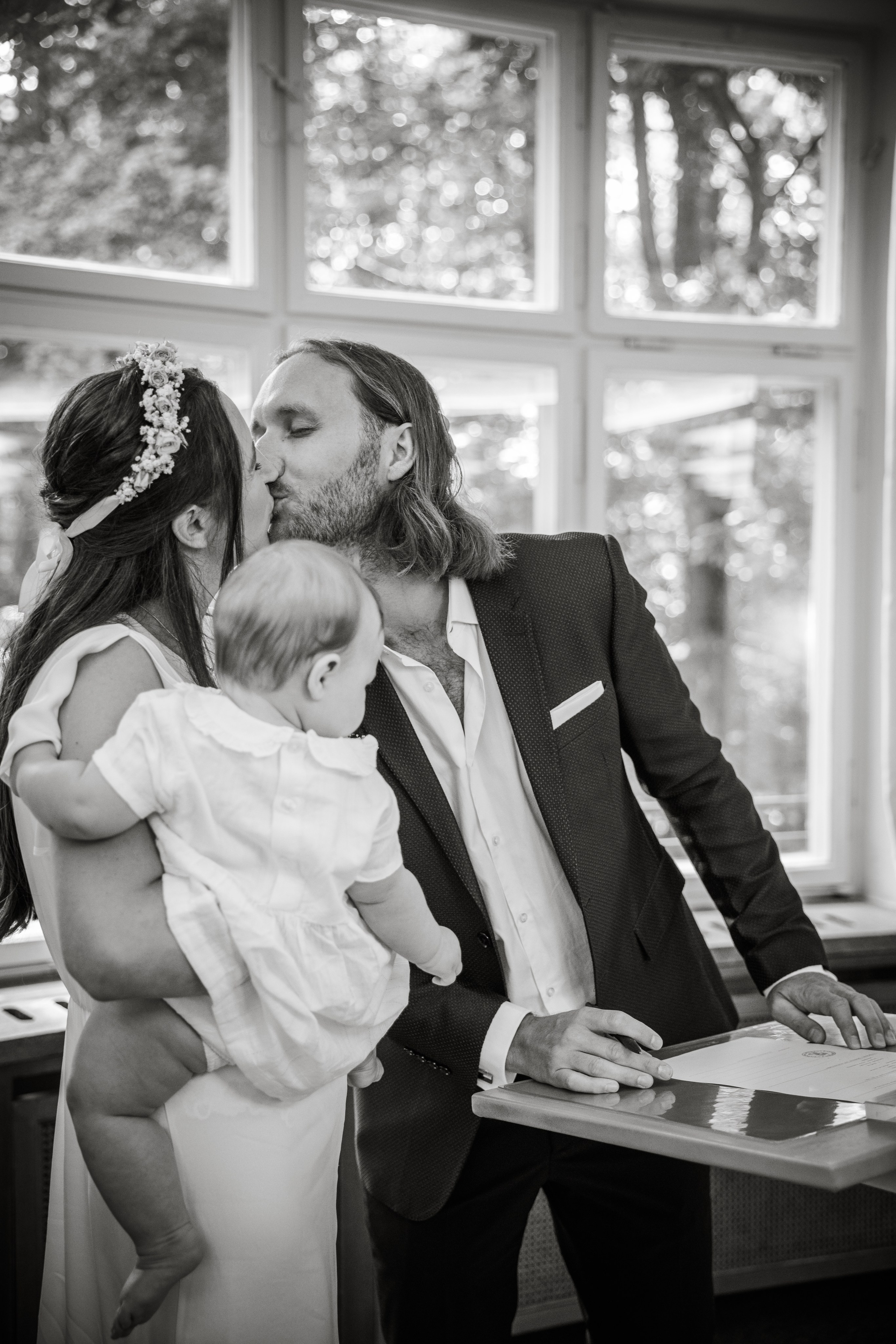 Braut und Bräutigam küssen sich nach der Unterzeichnung der Traupapiere – glücklicher Moment