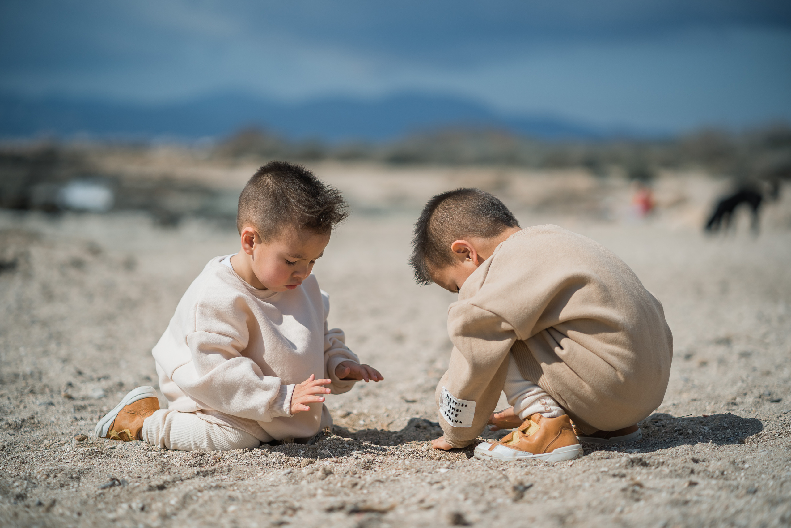 Zwei kleine Kinder, die am Strand in Can Pastilla auf Mallorca Sandburg bauen