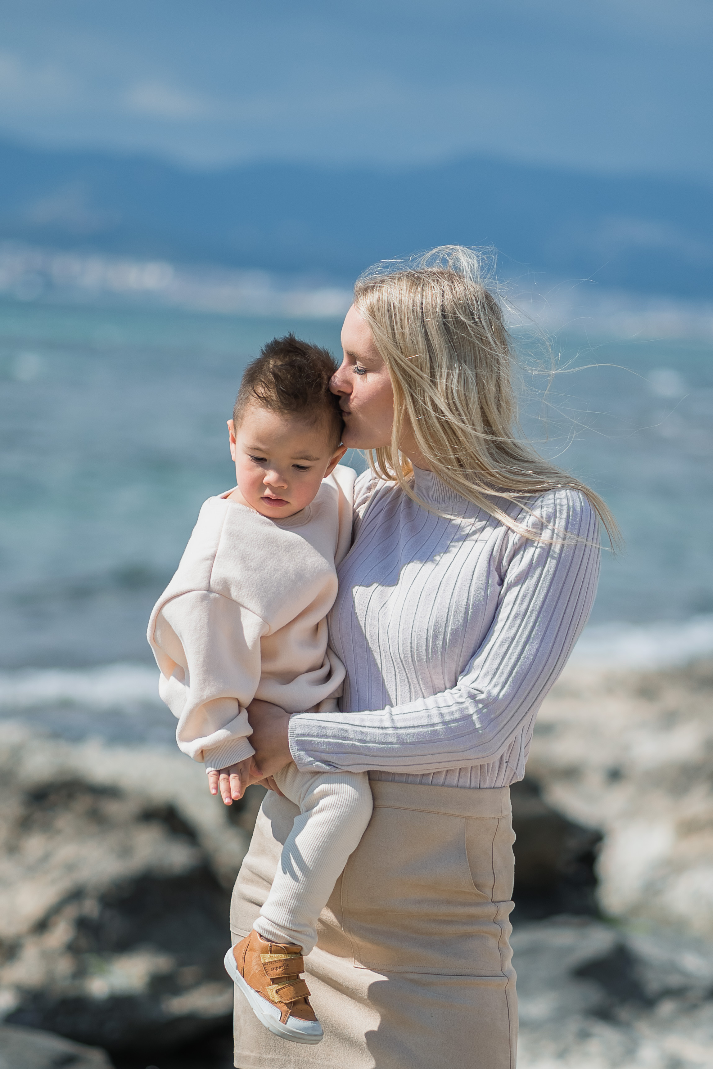 Eine Mutter, die mit ihrem Sohn am Strand von Arenal auf Mallorca kuschelt