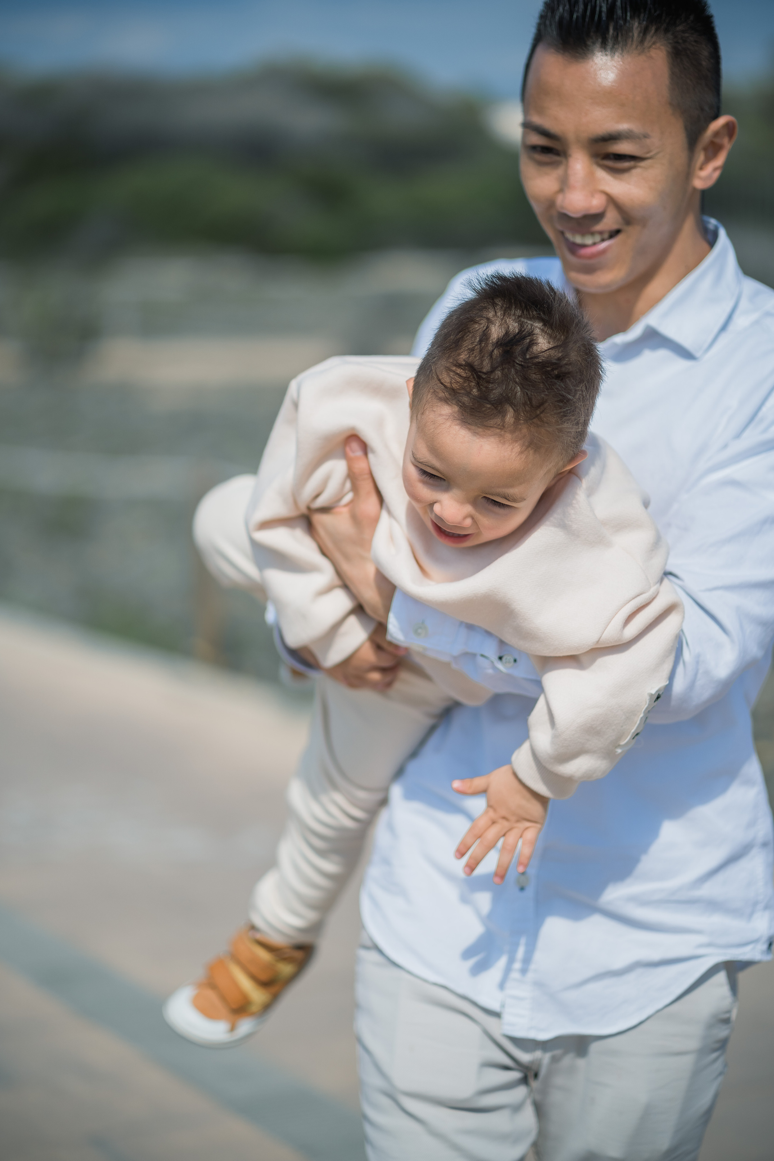 Ein Vater, der sein Kind am Strand von Palma de Mallorca trägt