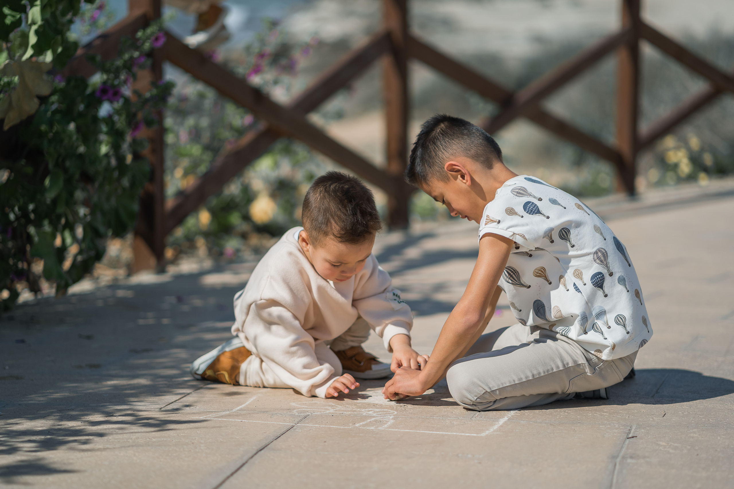 Zwei kleine Kinder, die am Strand in Palma de Mallorca Sandburg bauen