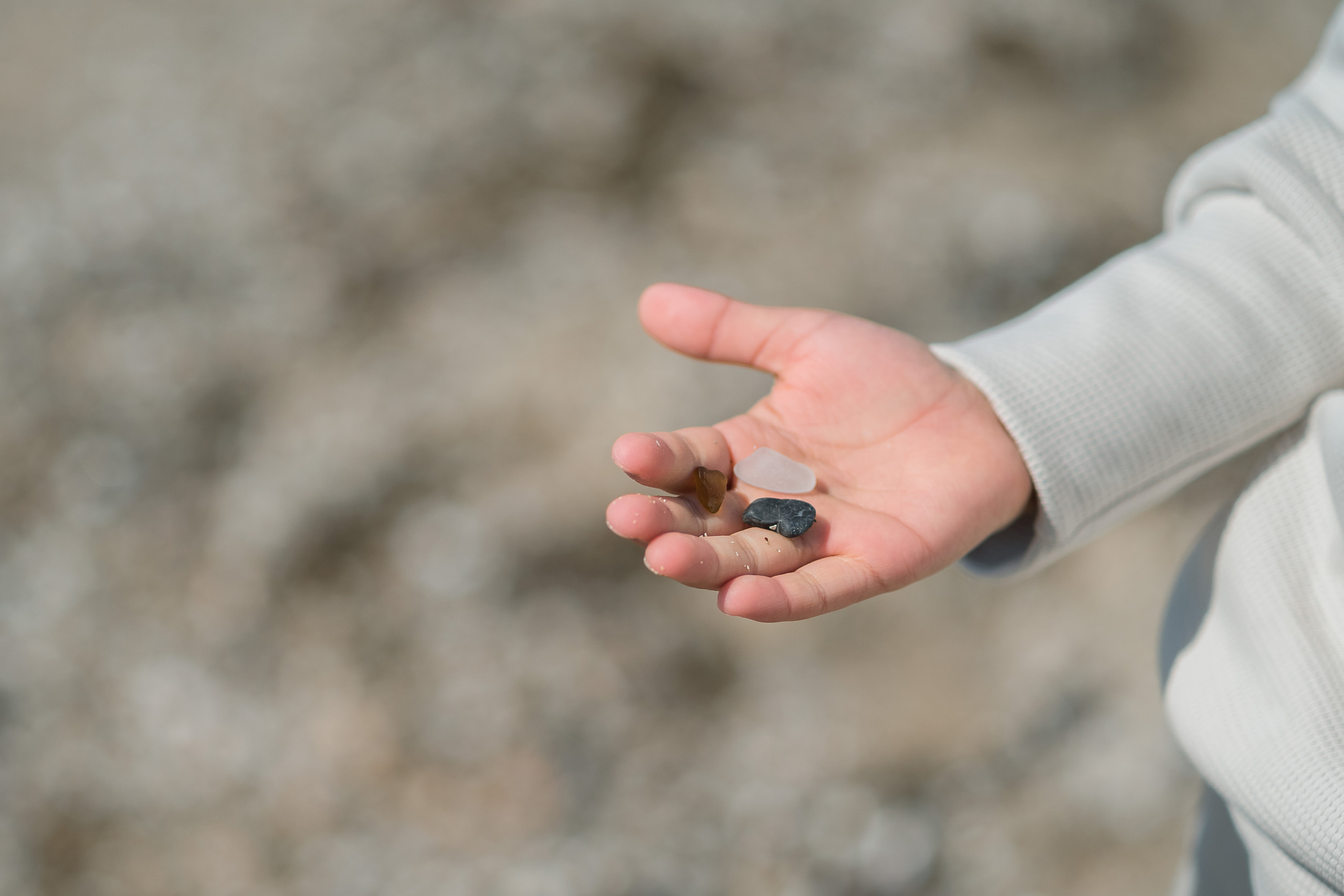 Ein Kind, das am Strand von Palma de Mallorca Steine sammelt