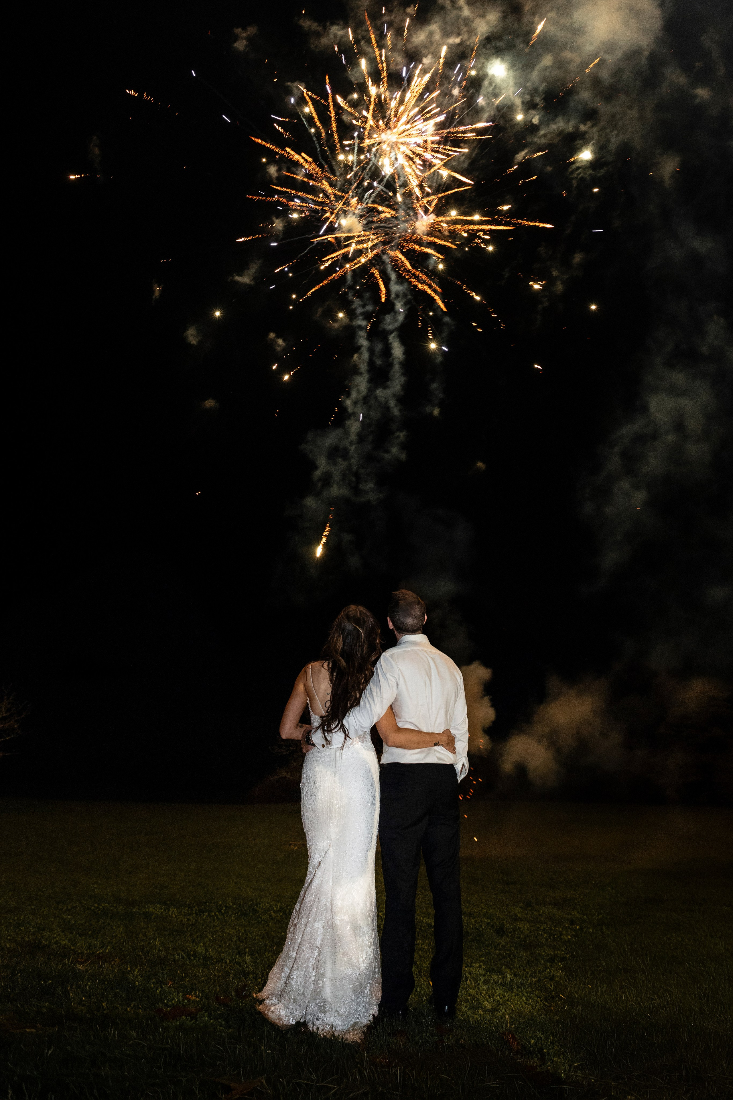 Bride and groom watching fireworks in the courtyard of Château Lagut, Dordogne.