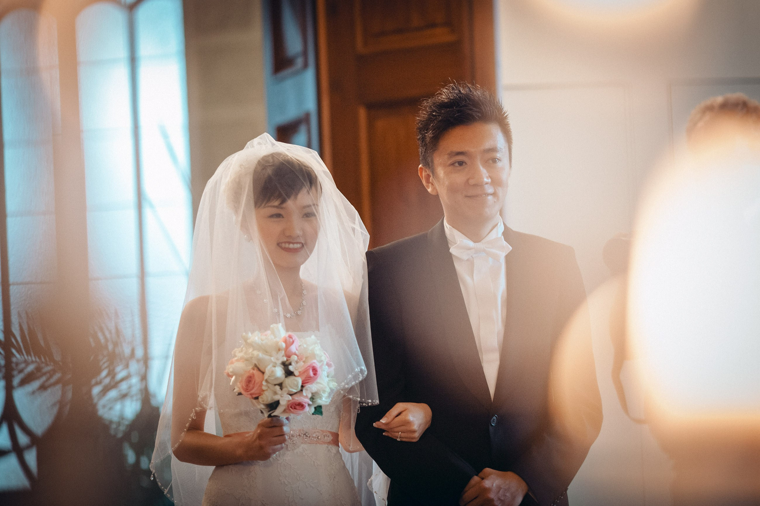 A bride from Hong Kong is escorted into the historic ceremonial hall of the State Chateau of Hluboka during her destination wedding in Bohemia.