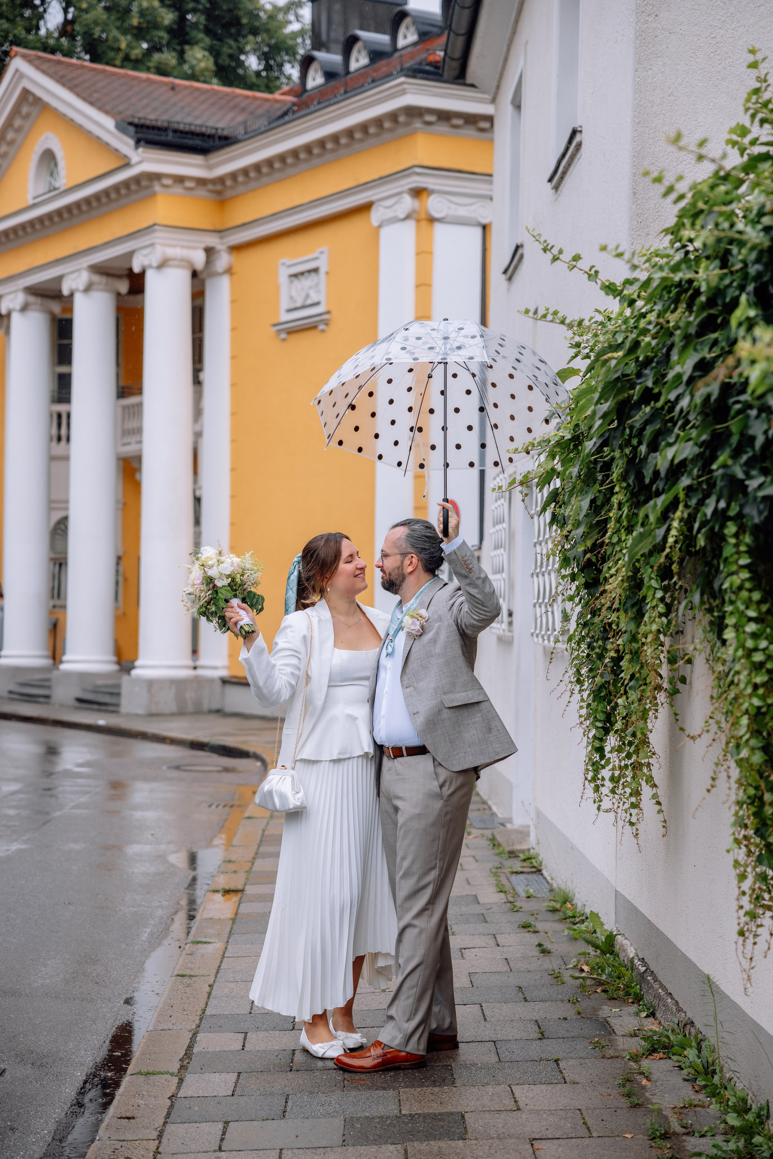 Brautpaar unter Regenschirm – zärtliche Blicke, sanftes Licht