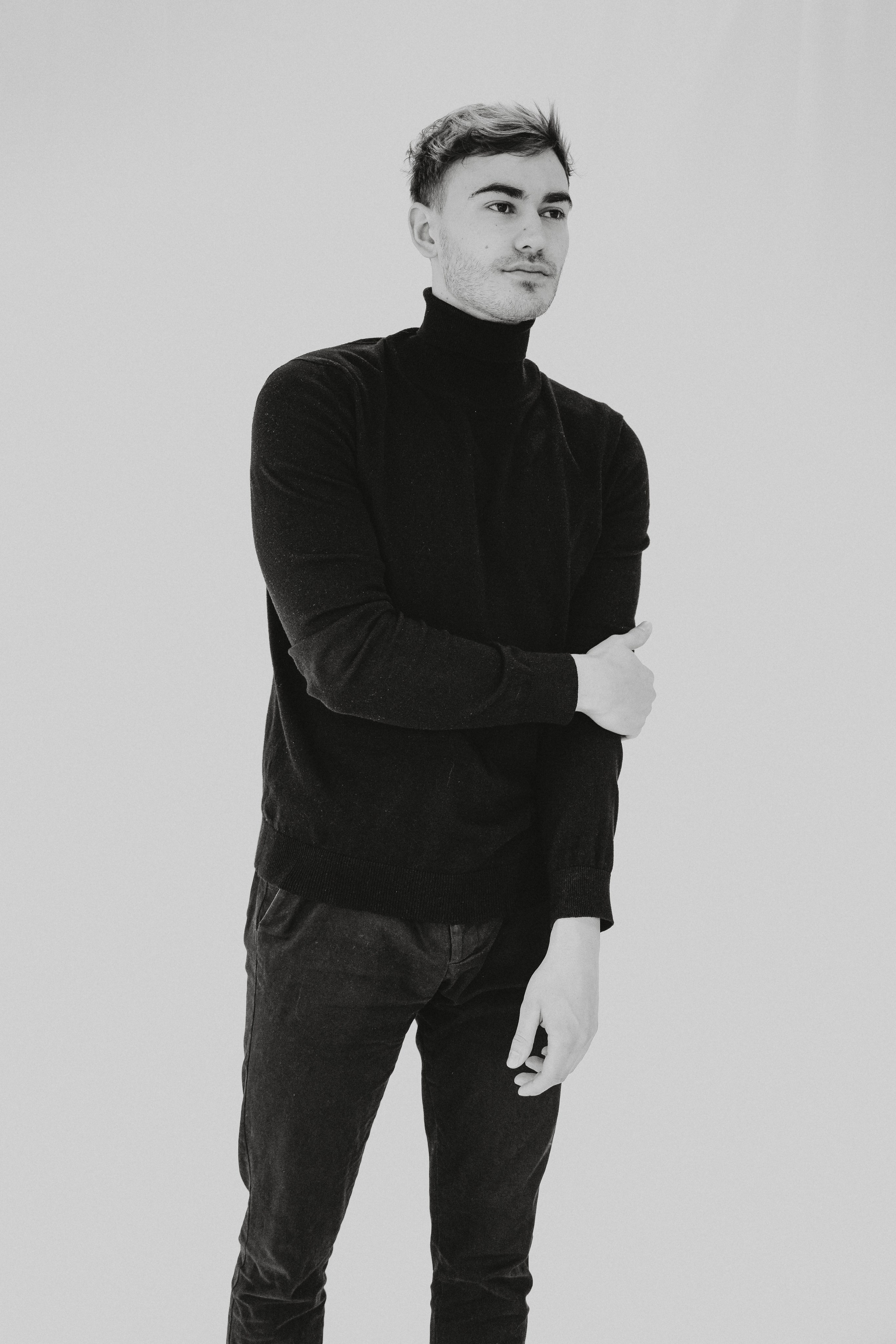 Minimalist fashion test shoot of male model in monochrome outfit, posing confidently in studio lighting.