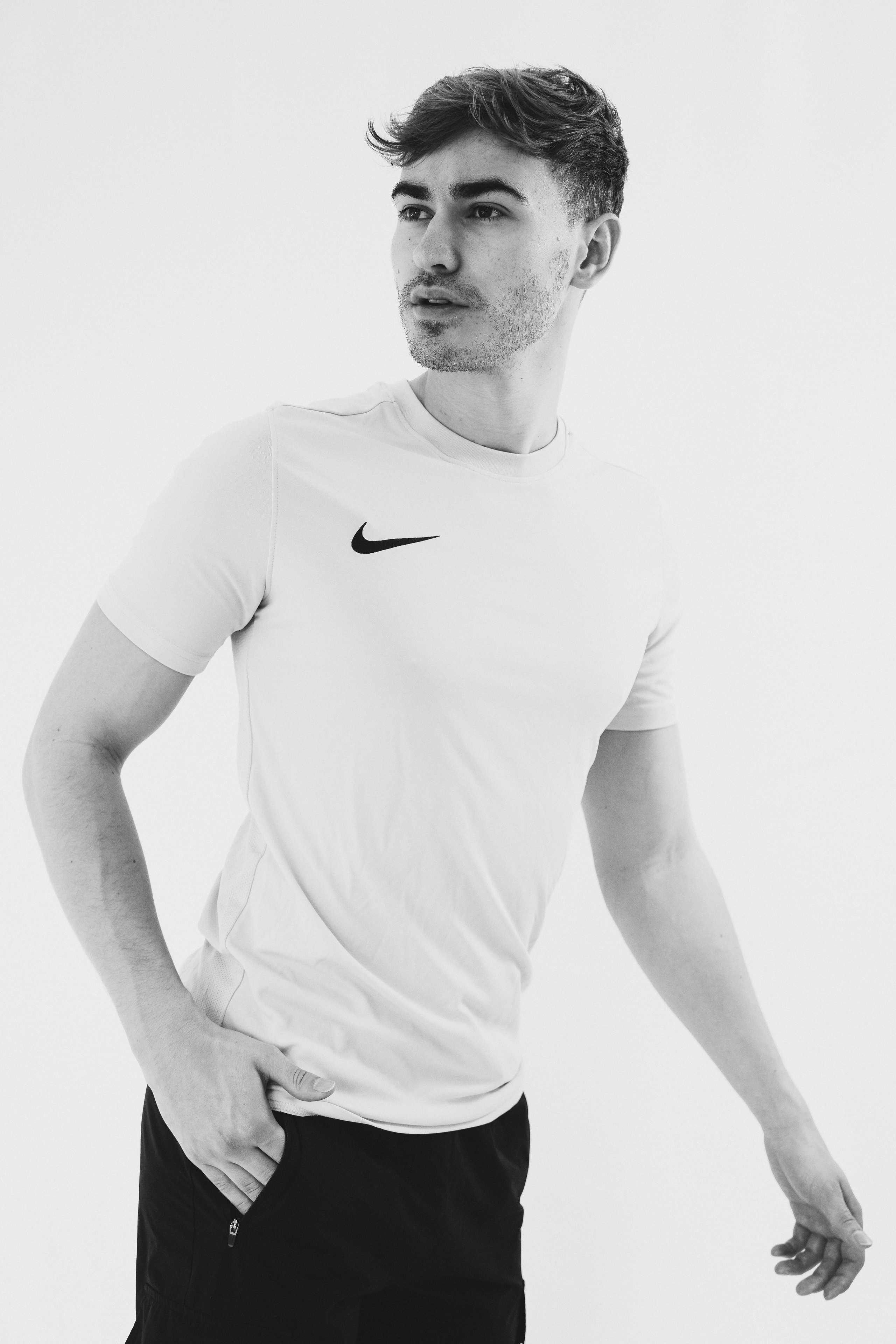 Young male talent posing naturally, hands in pocket, with minimal styling.