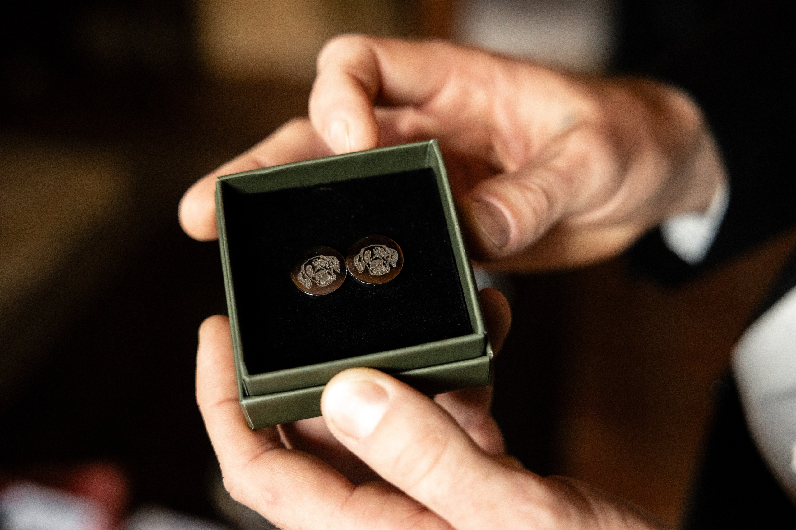 Close-up of custom cufflinks with dog engraving – meaningful wedding detail.