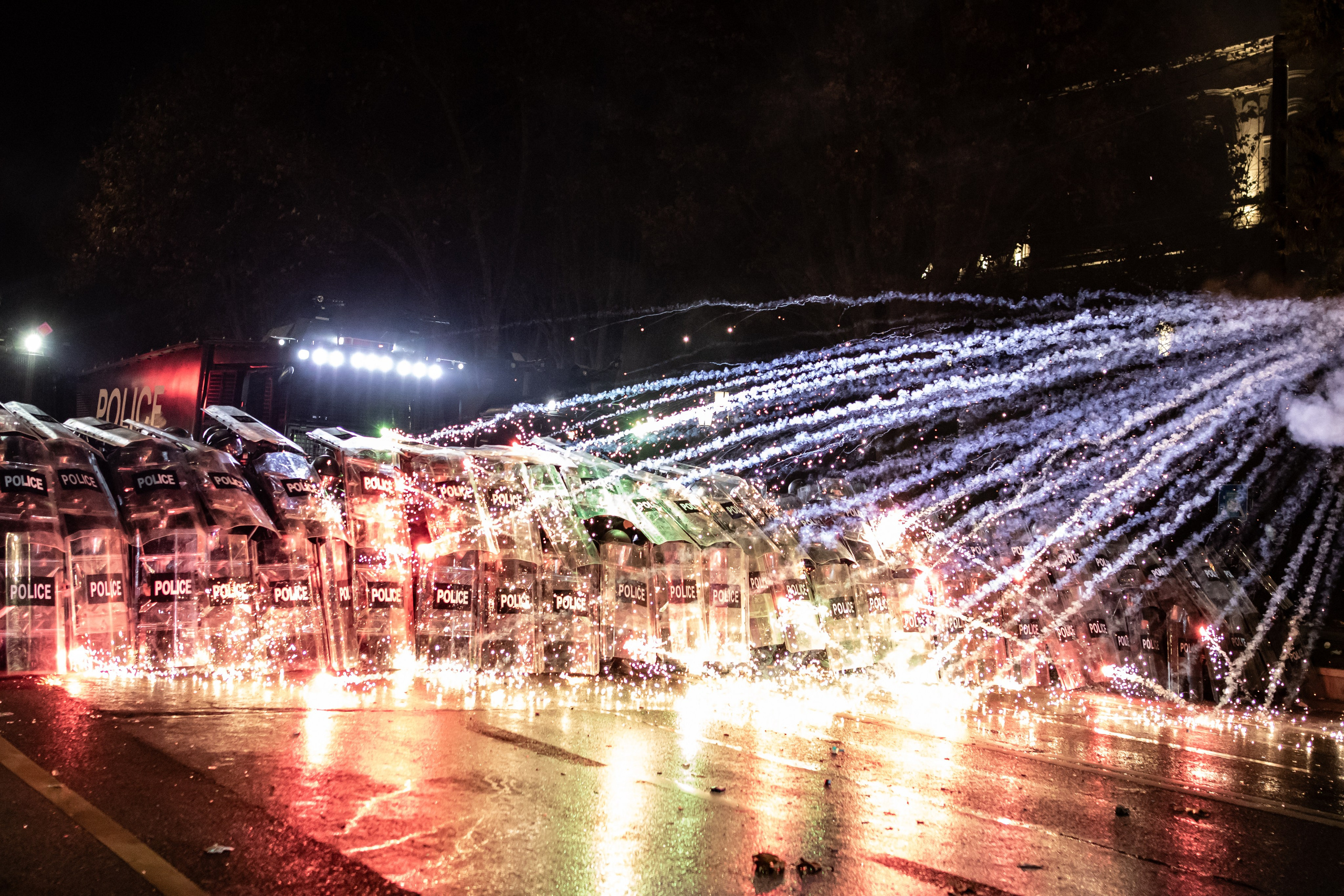 Les manifestants lancent des feux d’artifice sur les forces de l’ordre devant le Parlement.
