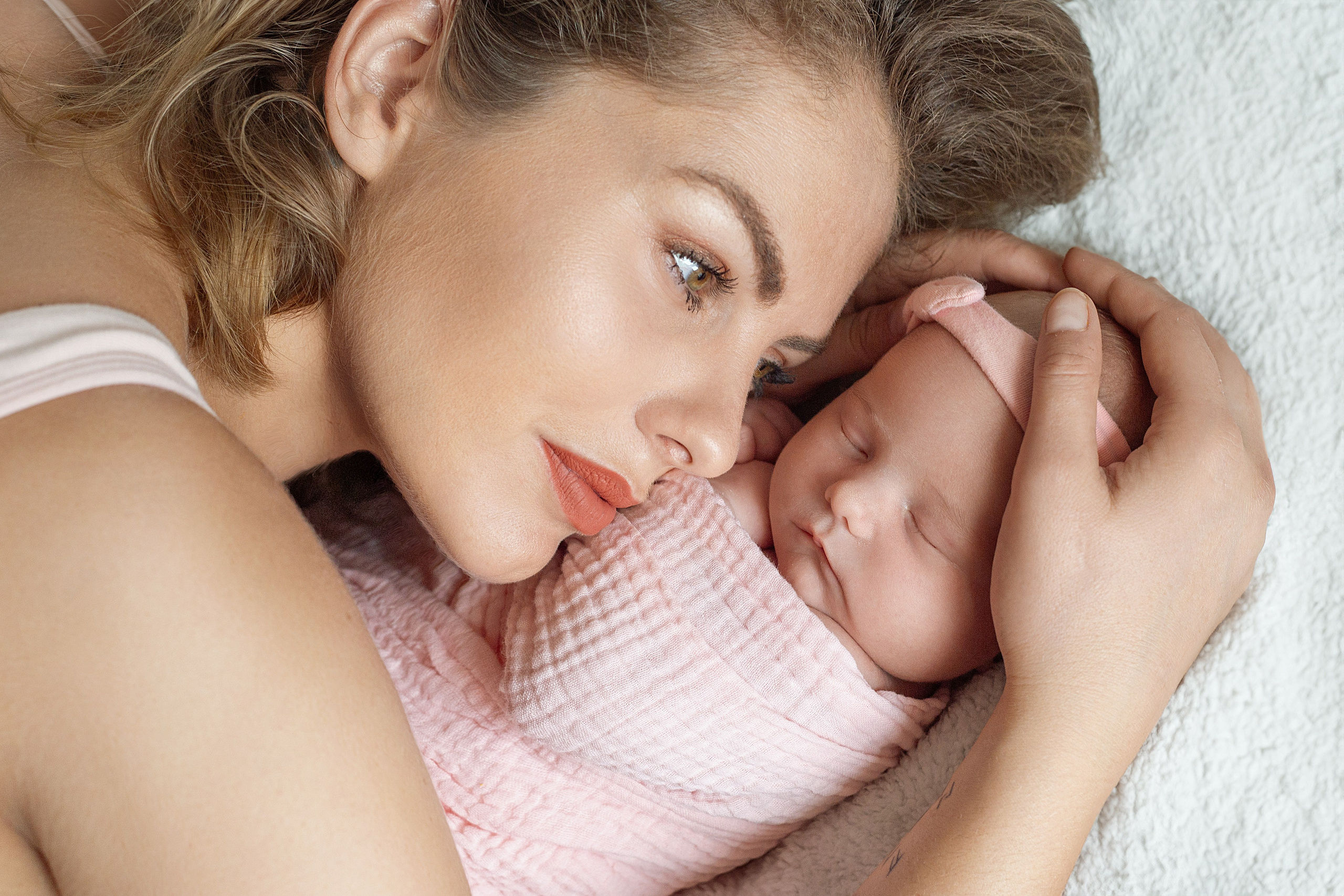 Maman et bébé dans une étreinte douce, séance photo nouveau-né pleine de tendresse