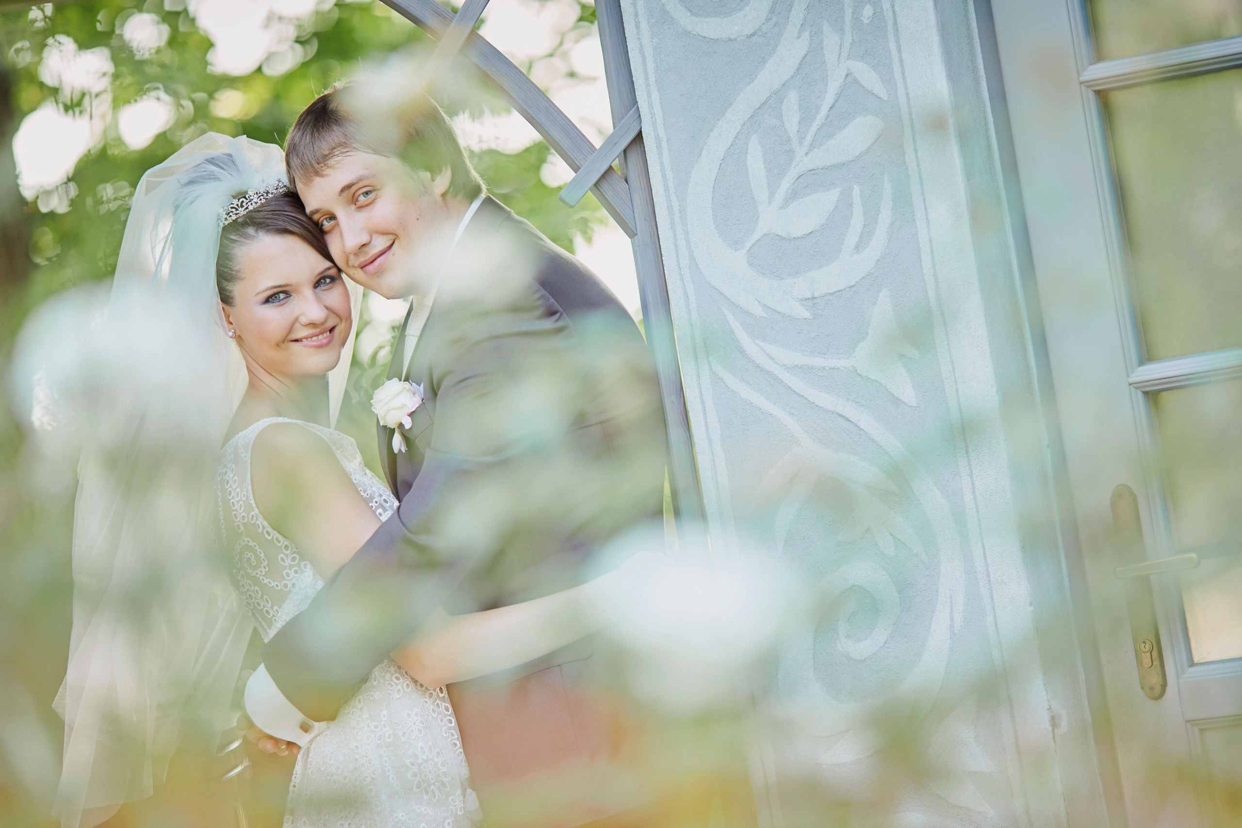 Love blossoms at Chateau Mcely as the bride and groom embrace amidst the scenic garden on their wedding day.