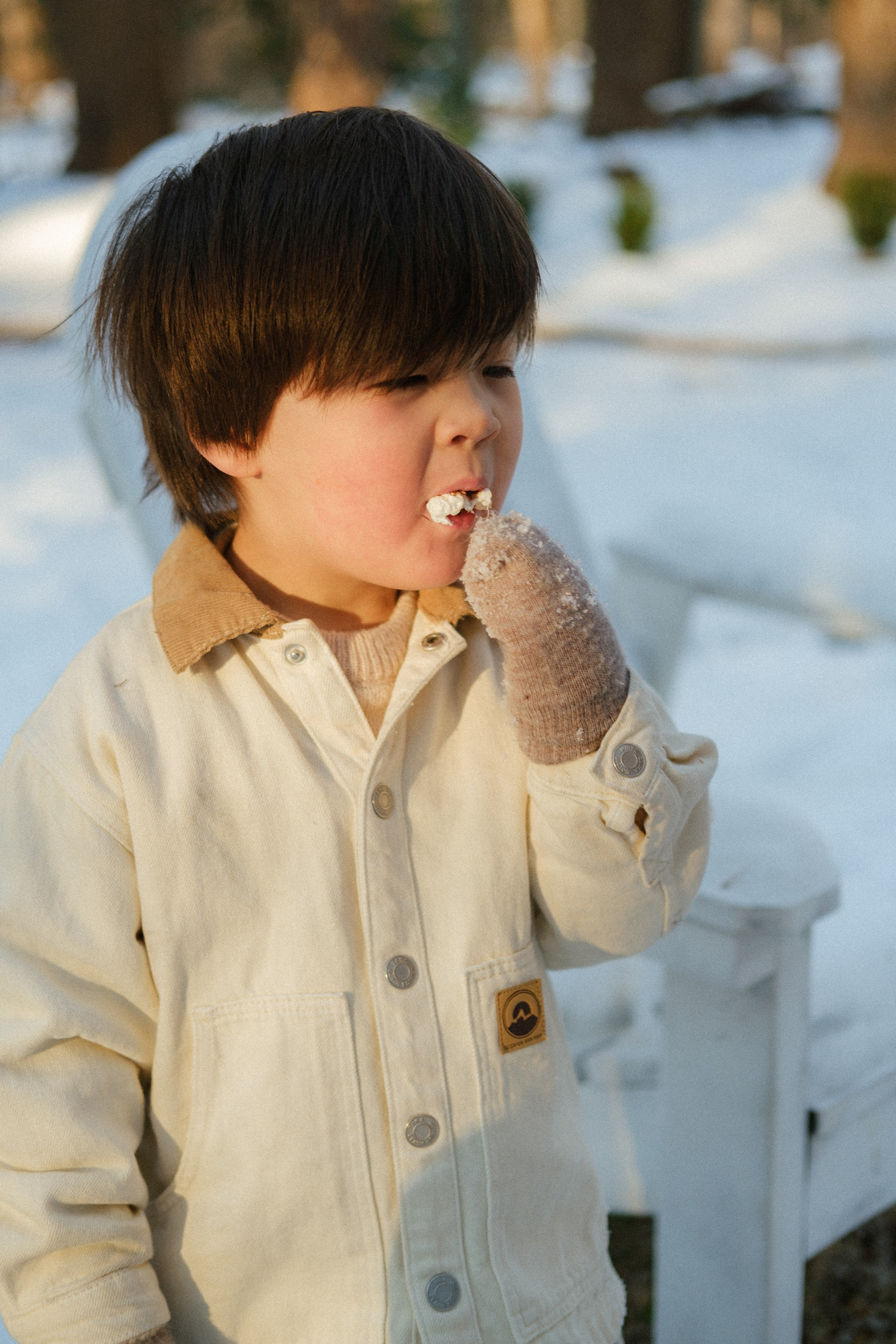 Smiling child holding a toasted marshmallow during a cozy family session in Richmond, VA — sweet, sticky joy.
