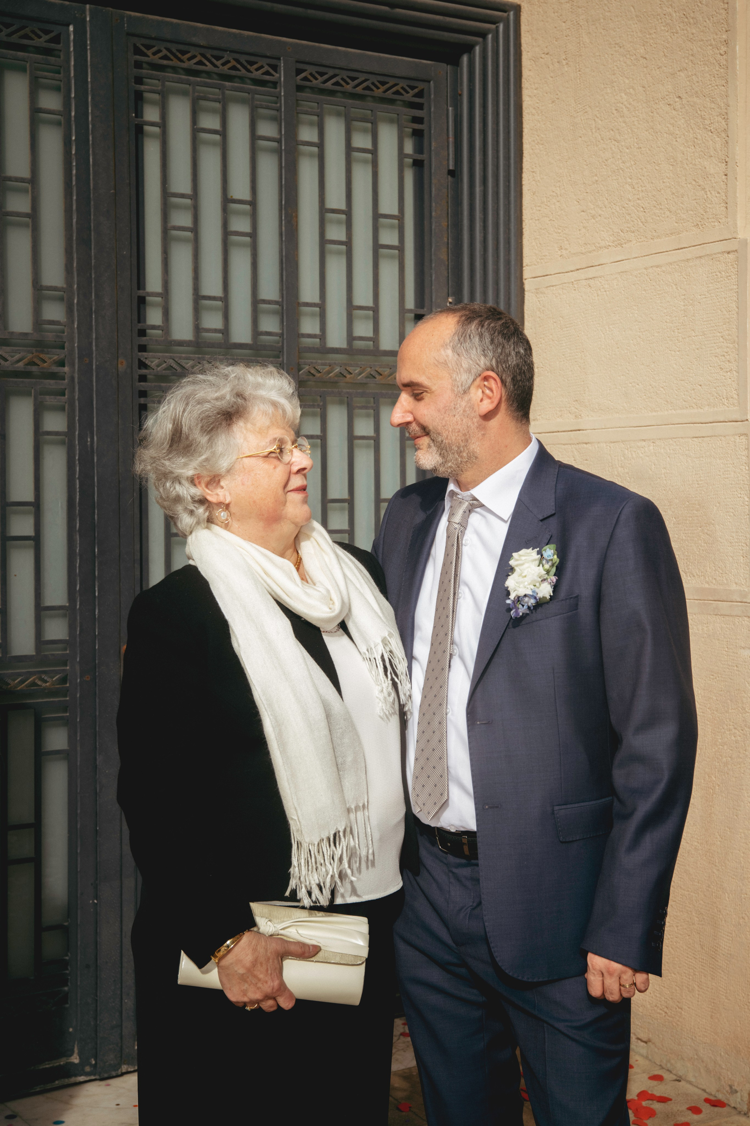 Жених и его мама обнимаются на свадьбе.