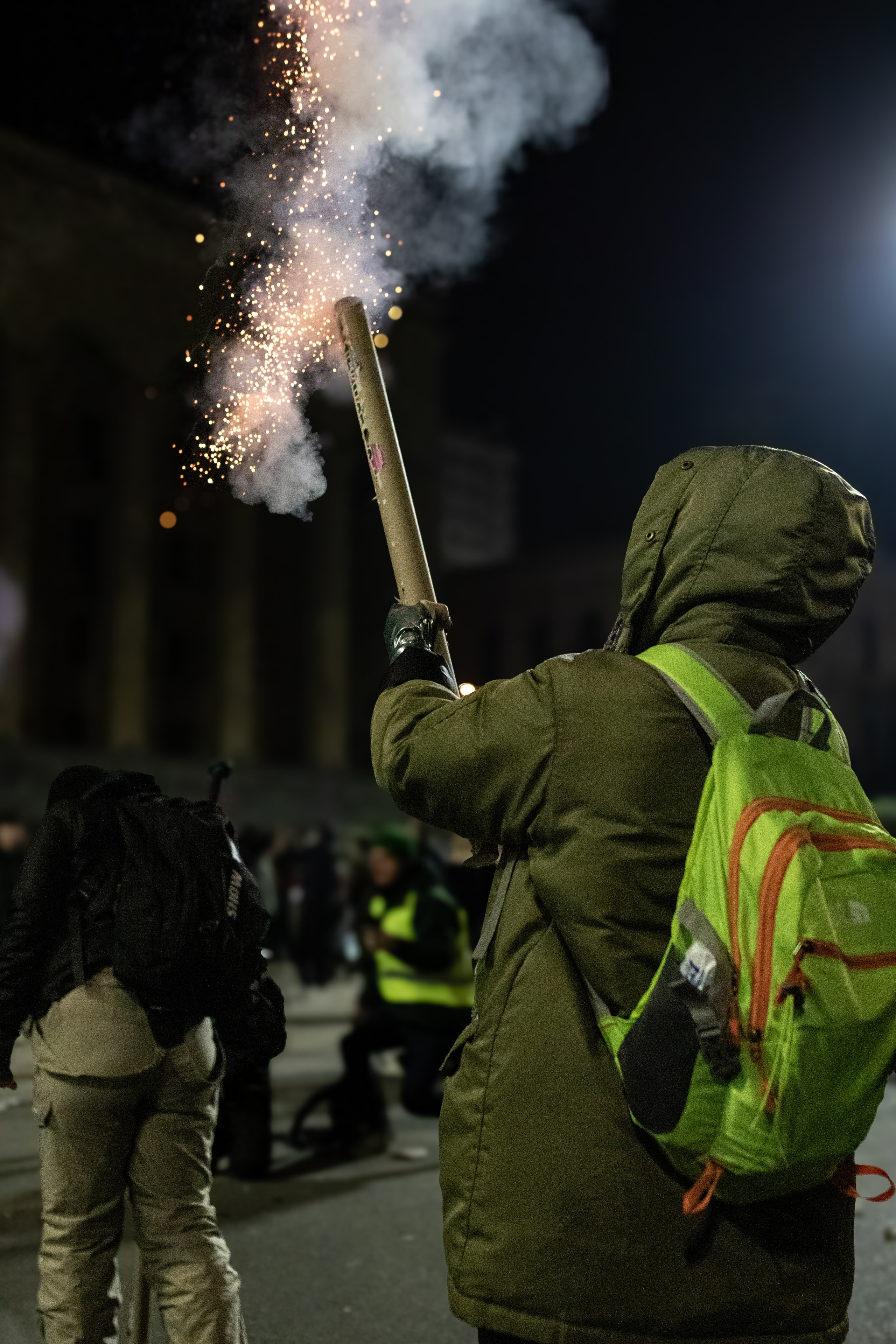 Une jeune manifestante tire un feu d’artifice sur le Parlement.