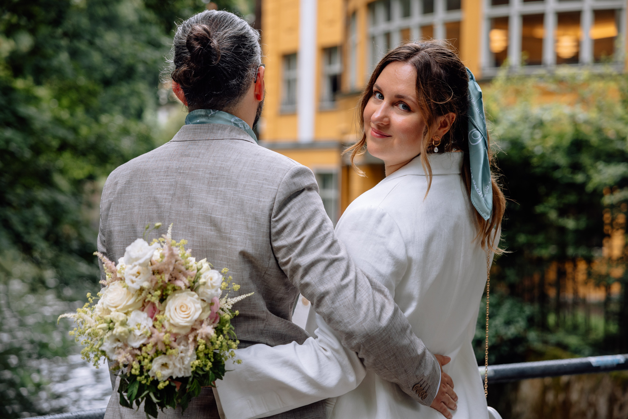 Paar von hinten fotografiert – Spaziergang am Bach neben Standesamt Schwabing