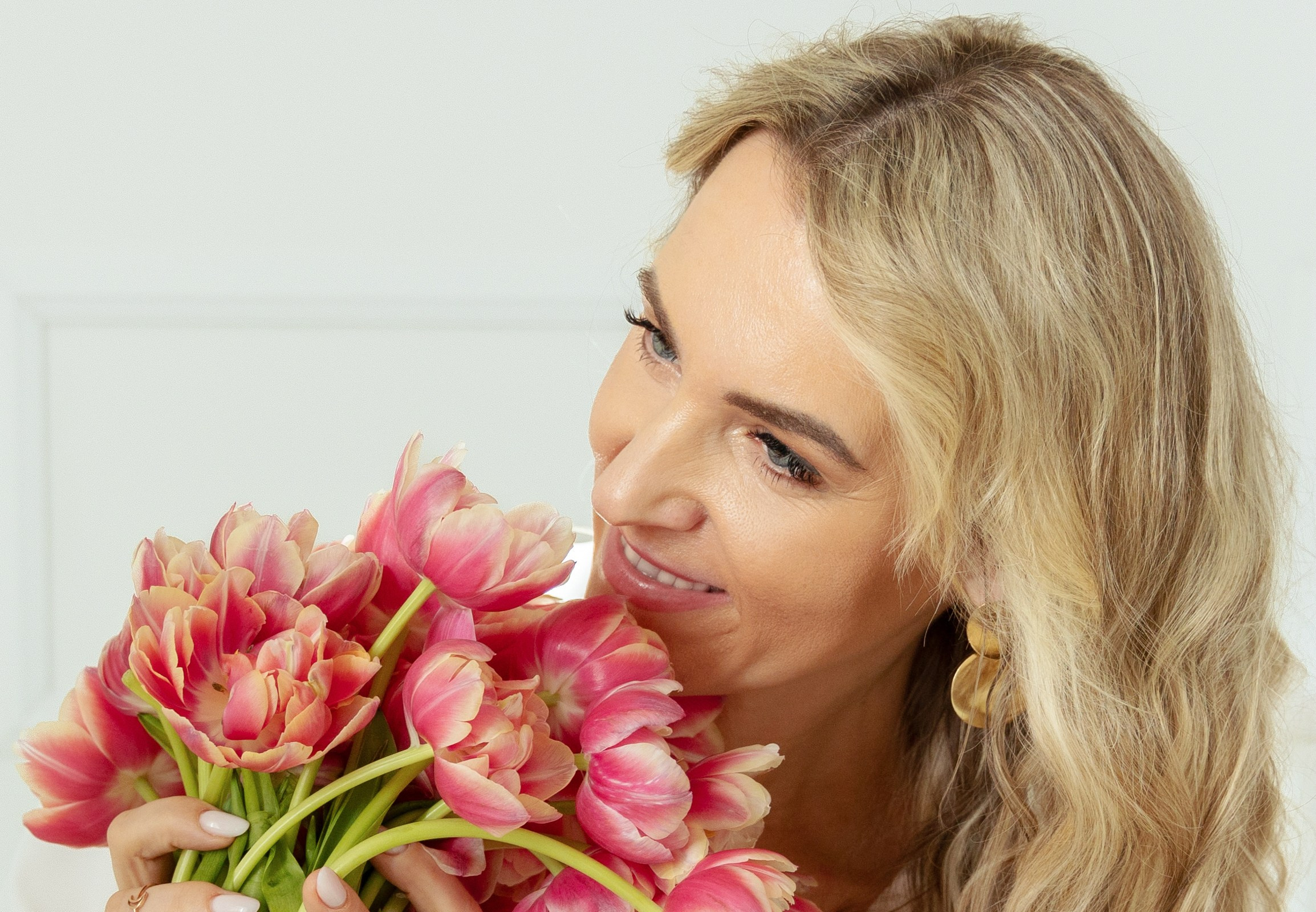 "Elegantes Studiofoto einer Frau mit Blumenstrauß. Die harmonischen Farben der Blüten und ihr sanfter Gesichtsausdruck vermitteln eine ruhige, feminine Ausstrahlung."