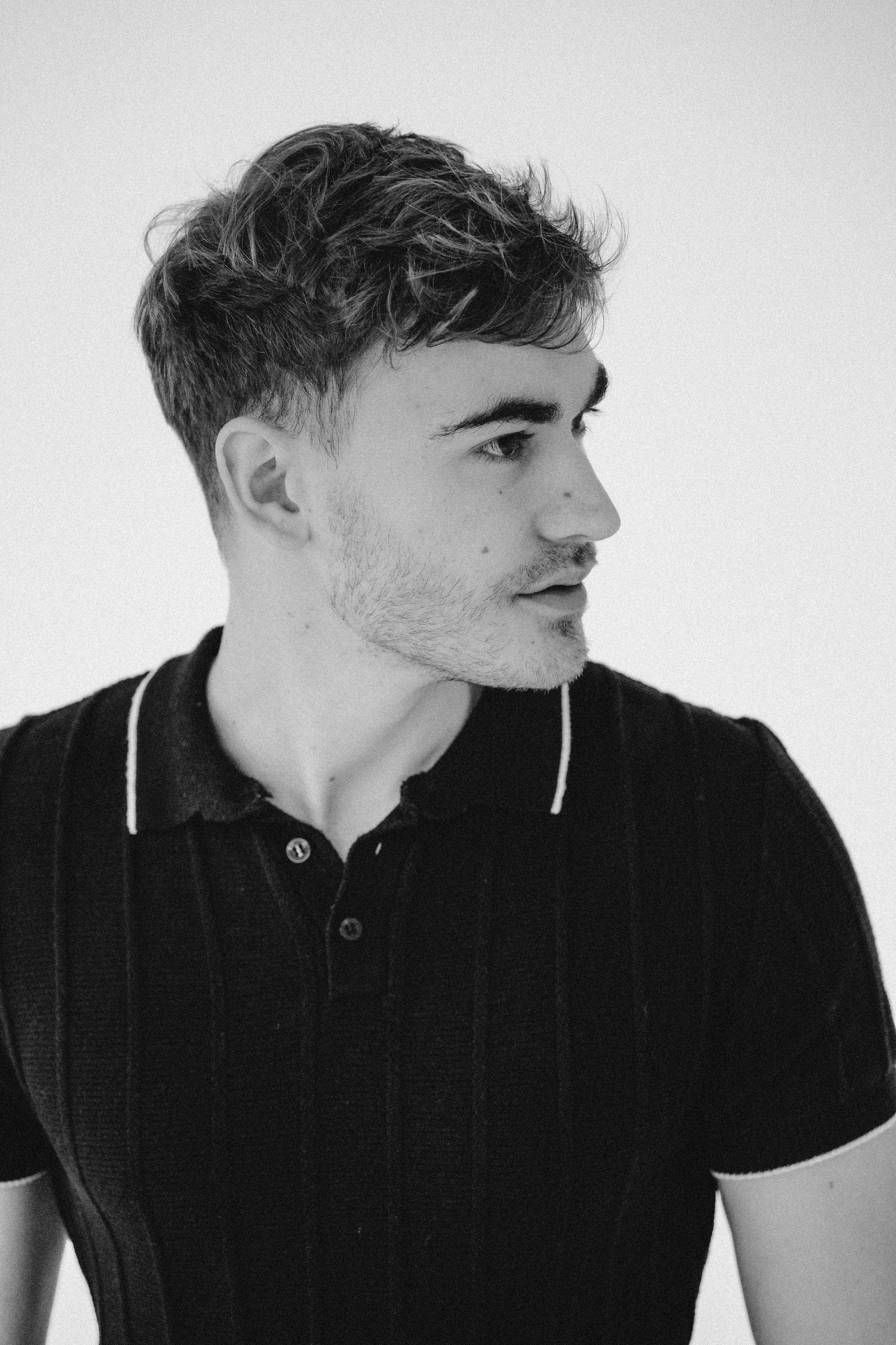 Studio headshot of male model with strong jawline and direct gaze.