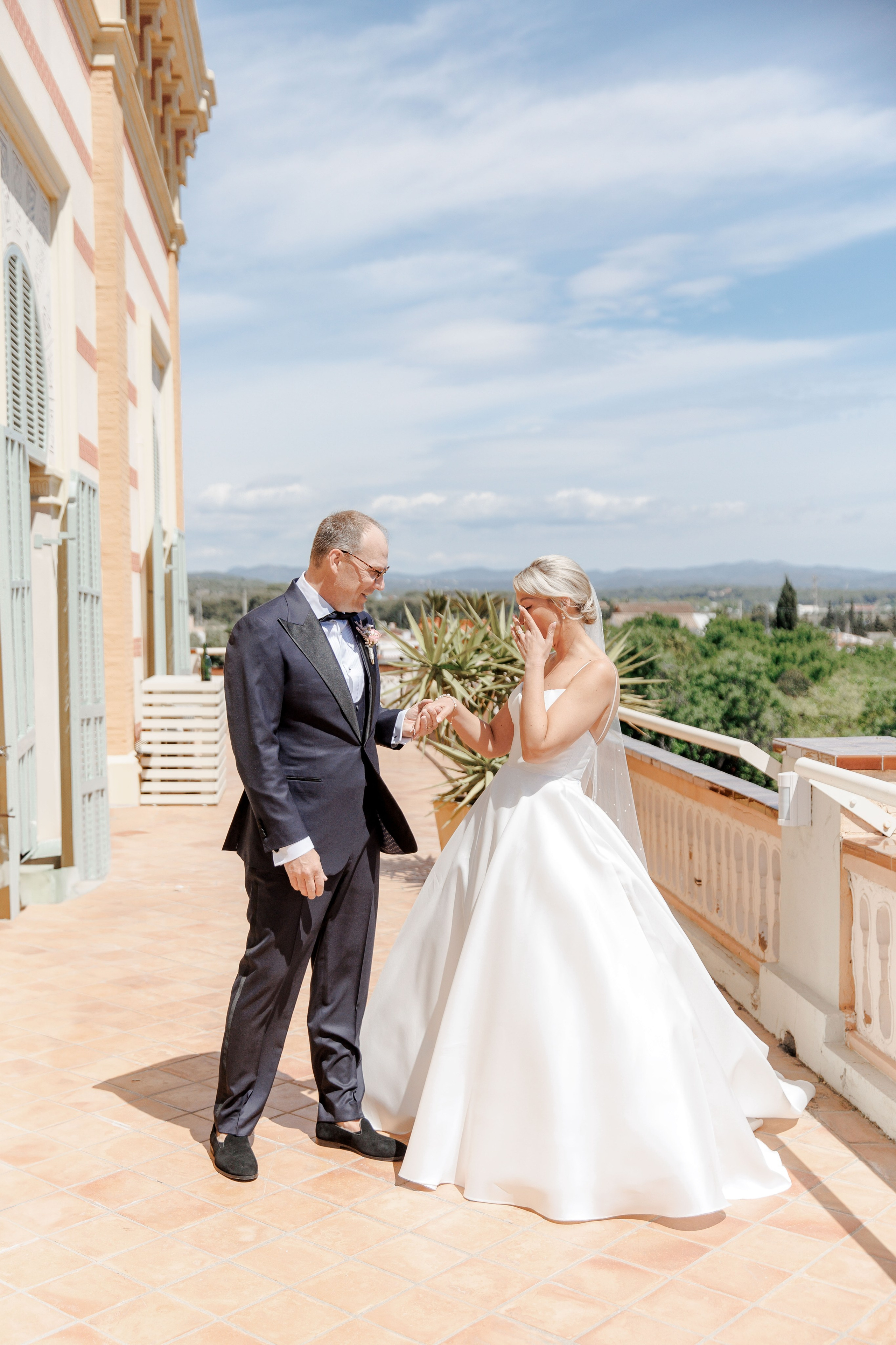 Emotional first look between the bride and groom in the picturesque terrace of the Spanish wedding venue.