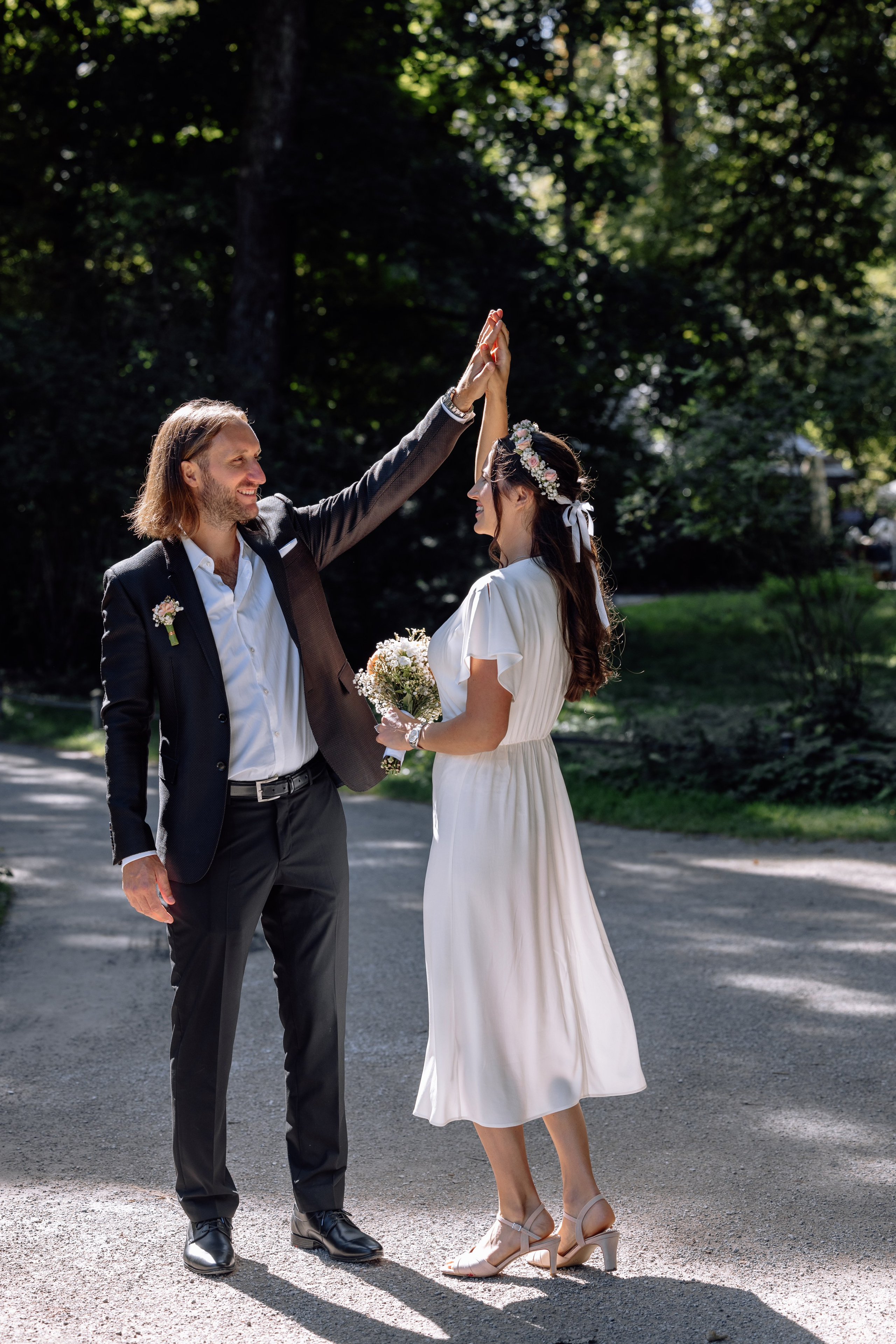 Braut und Bräutigam tanzen und wirbeln im Sonnenlicht des Englischen Gartens