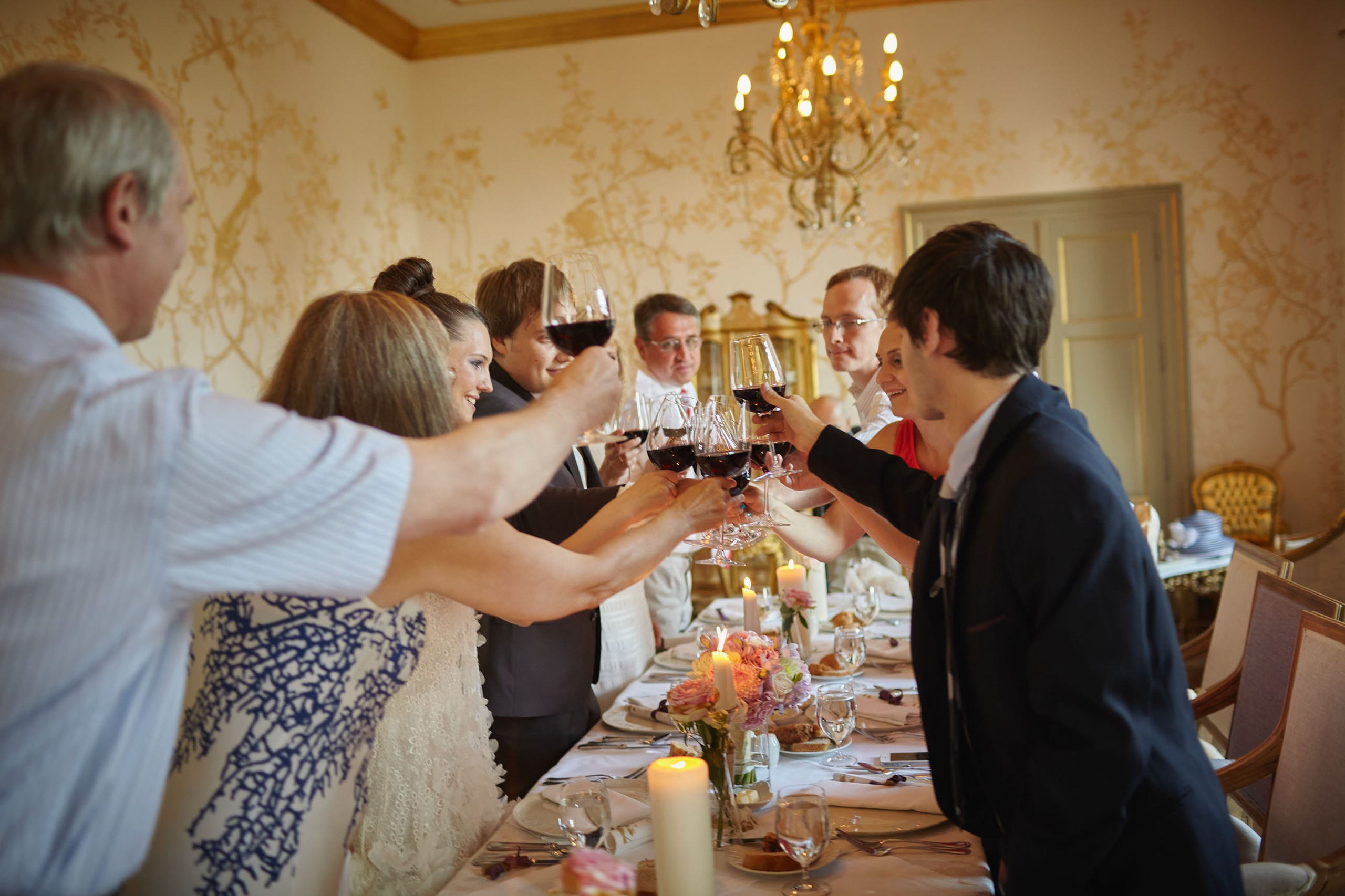 Family and friends toast to the newlyweds with red wine in their honor during their dinner at the Chateau Mcely.