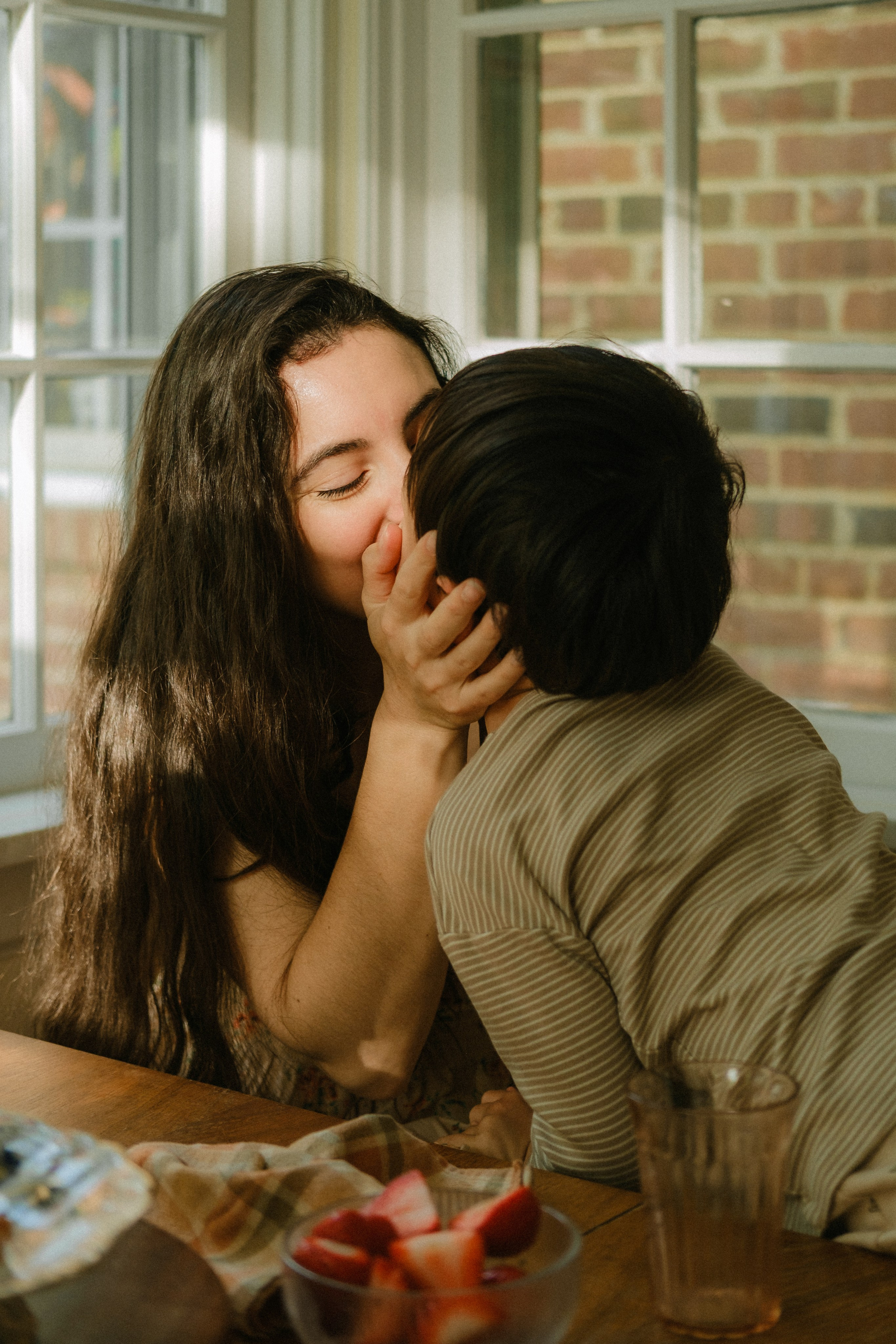 Mom giving a kiss to her baby boy while having breakfast in Richmond, VA