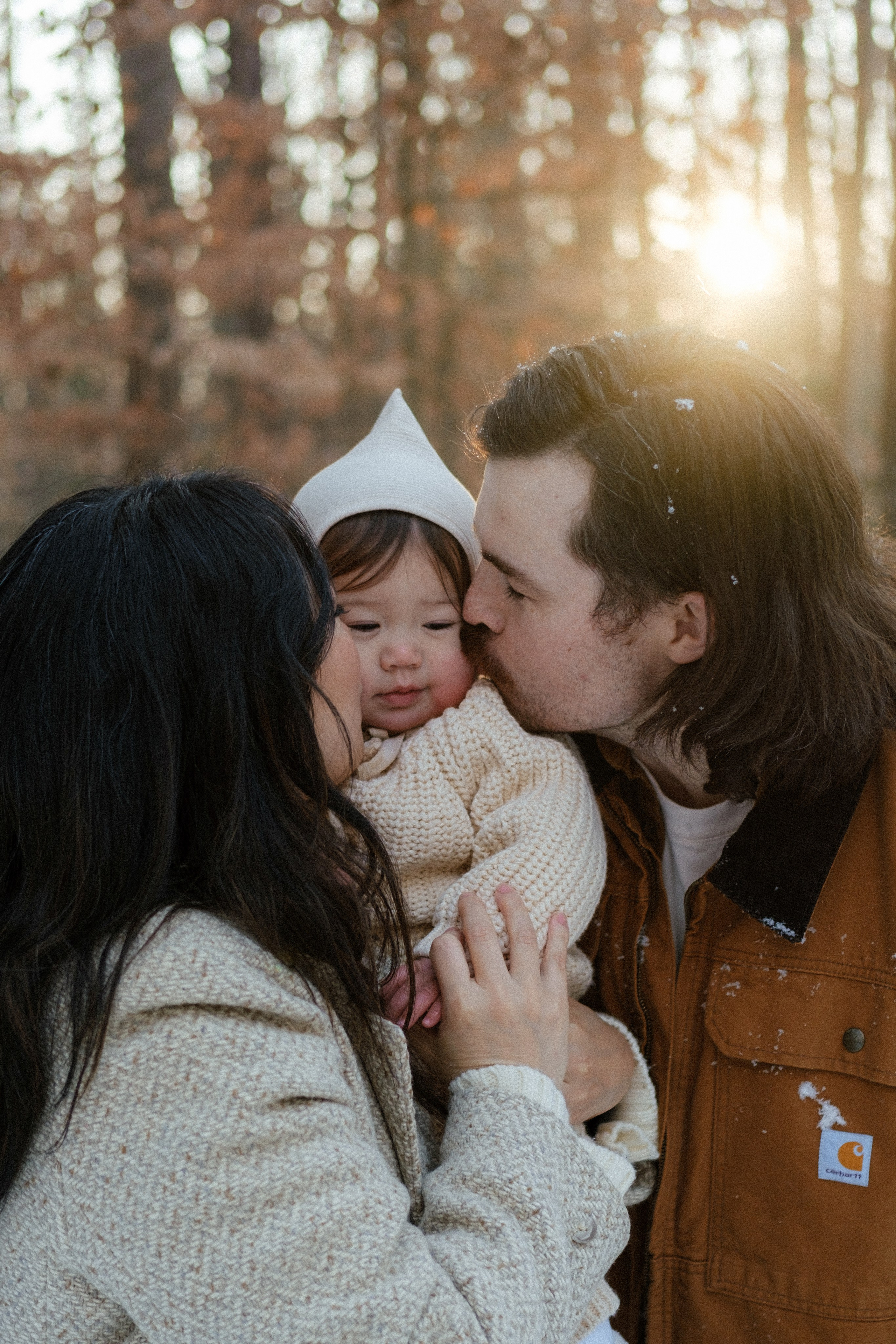 Golden hour sunlight streaming through snowy trees outside Richmond, VA — the perfect winter backdrop for family photos.