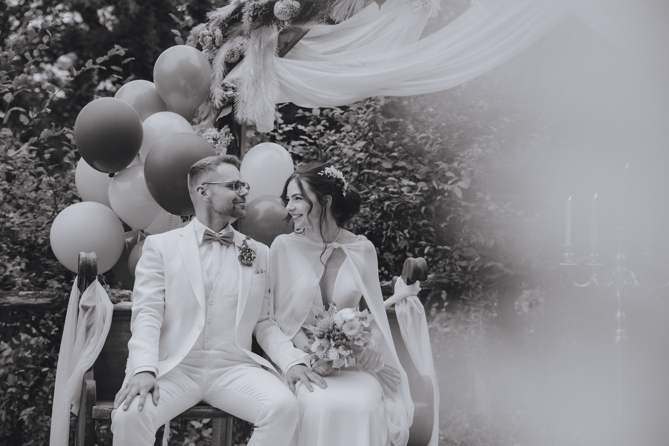 Der Bräutigam und die Braut schauen sich verliebt in die Augen.