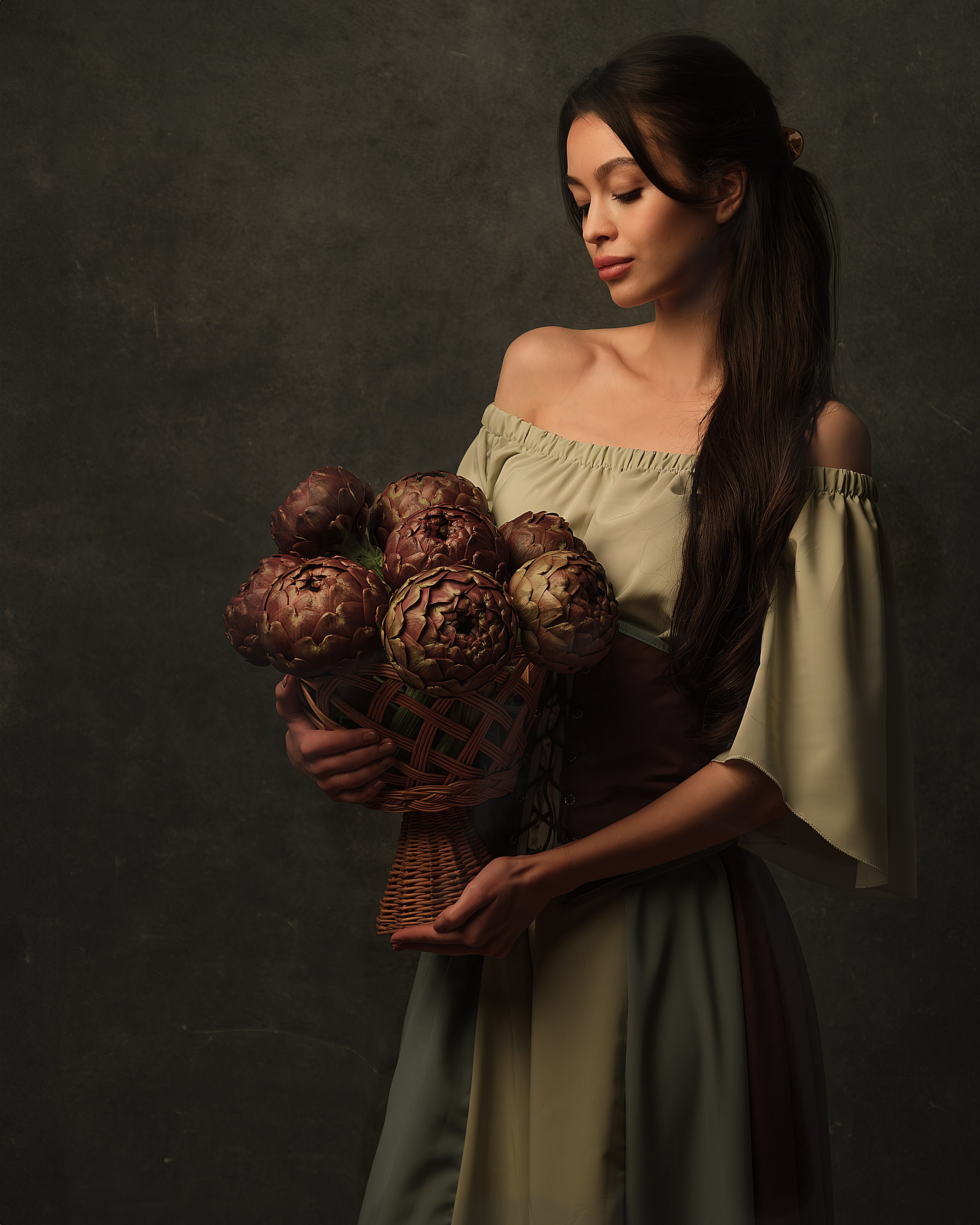 Ritratto fotografico in studio ragazza con mazzo di carciofi