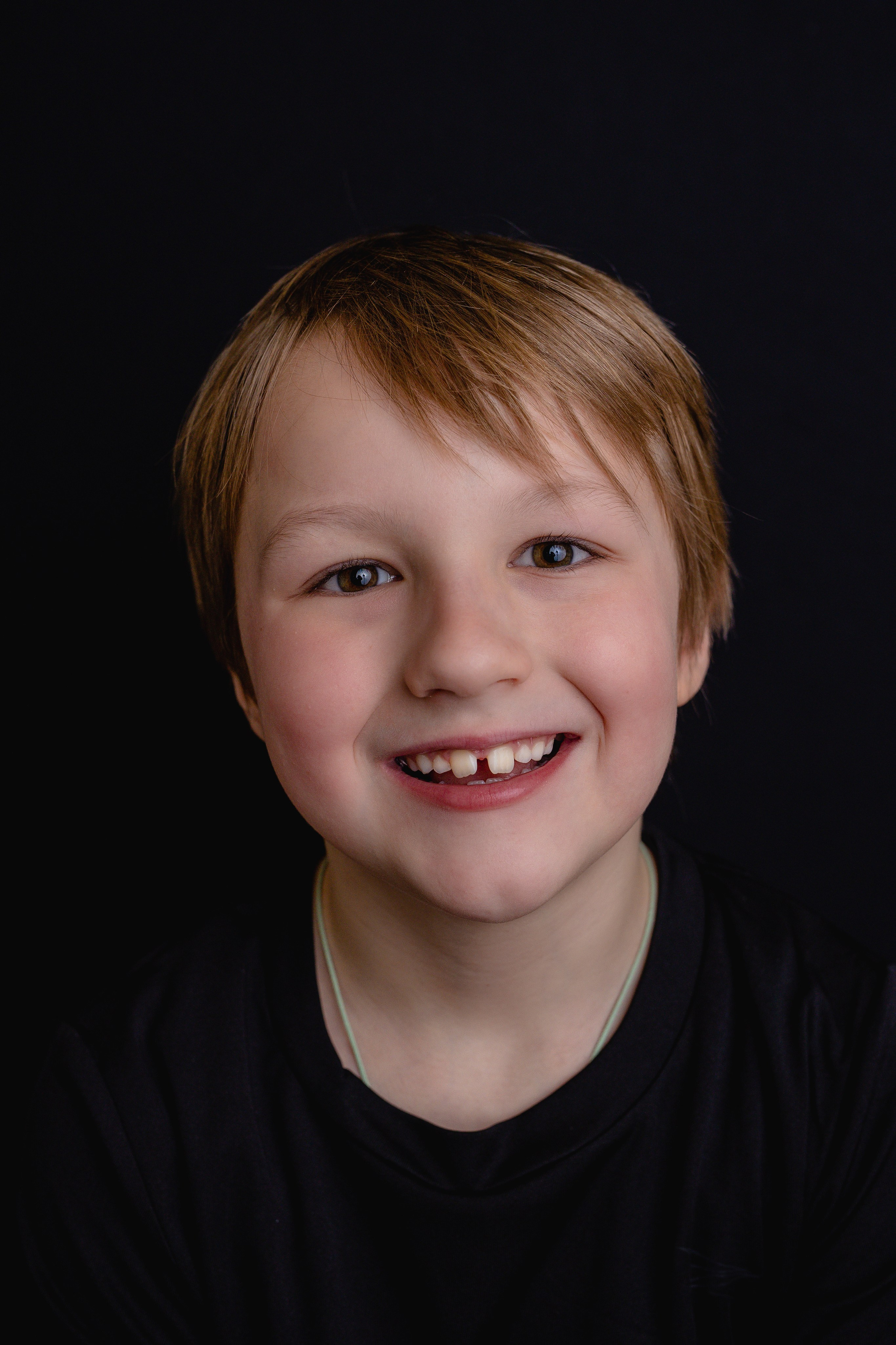 Portretfoto van een jongen met donkere achtergrond, genomen in Zwolle, Nederland