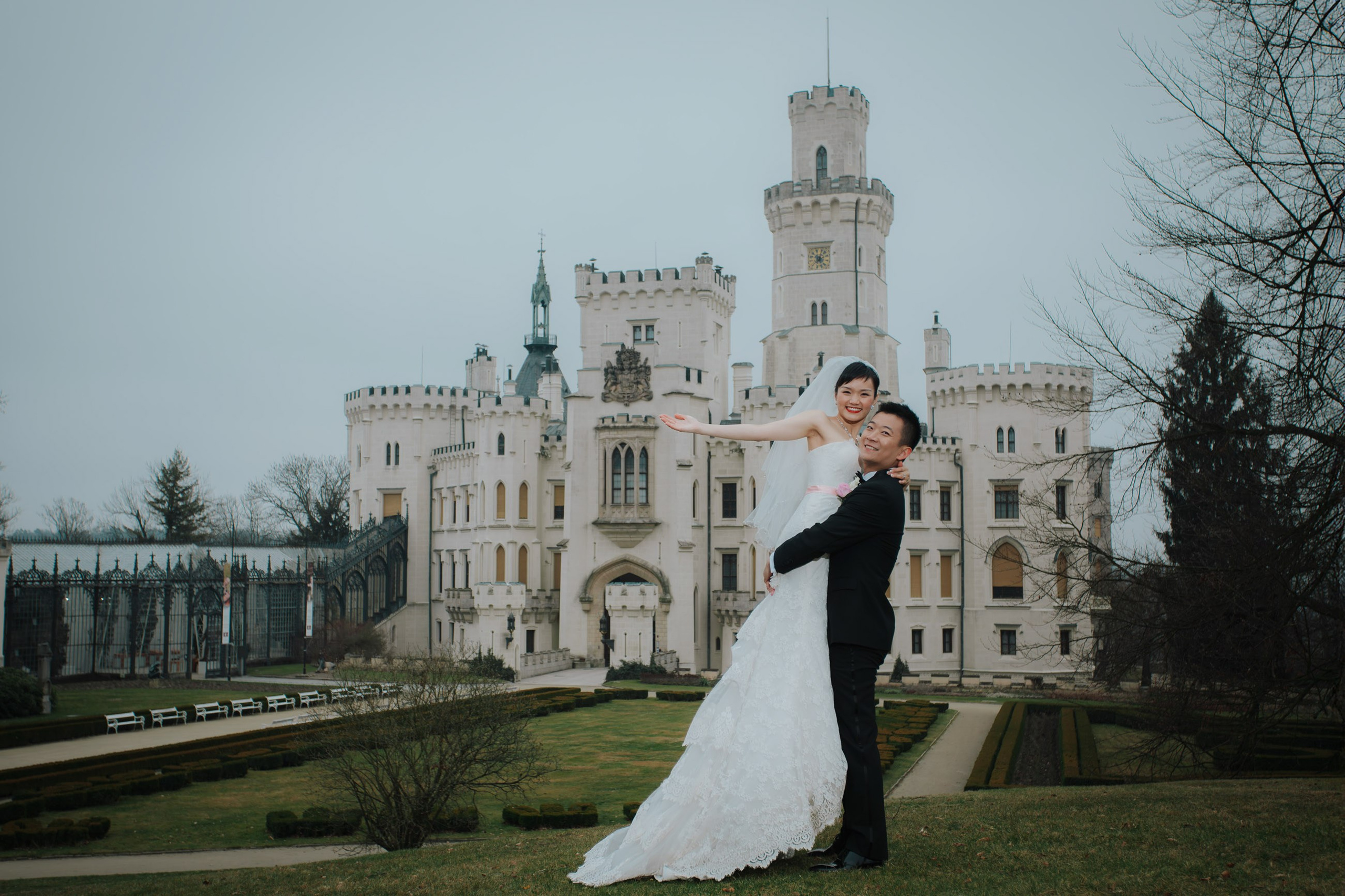 The smiling Hong Kong newlyweds emabrace against the backdrop of the State Chateau of Hluboka where they had earlier exchanged their wedding vows.