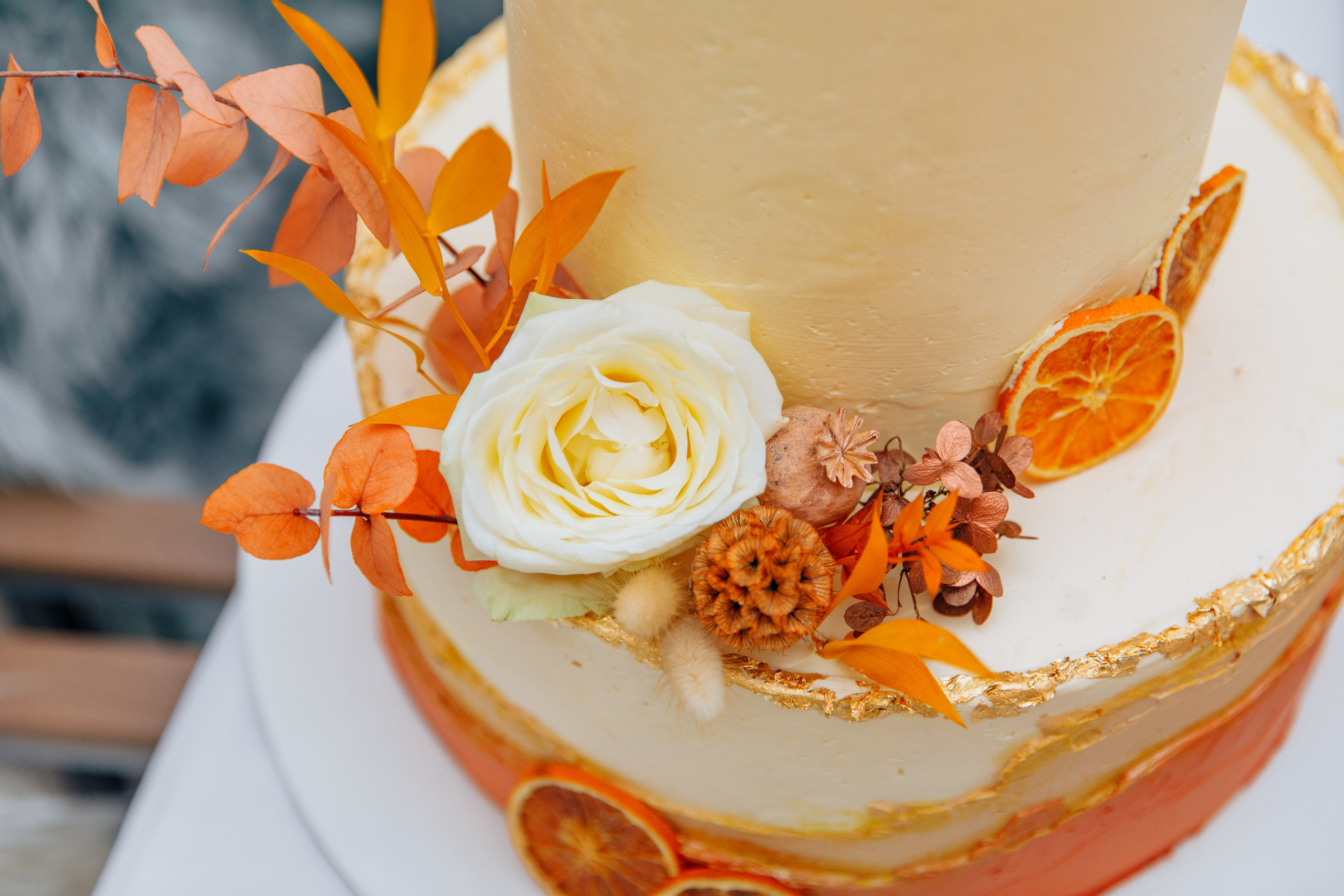 Herbstlicher Dekor für die Hochzeitstorte mit getrockneten Blumen und natürlichen Akzenten.