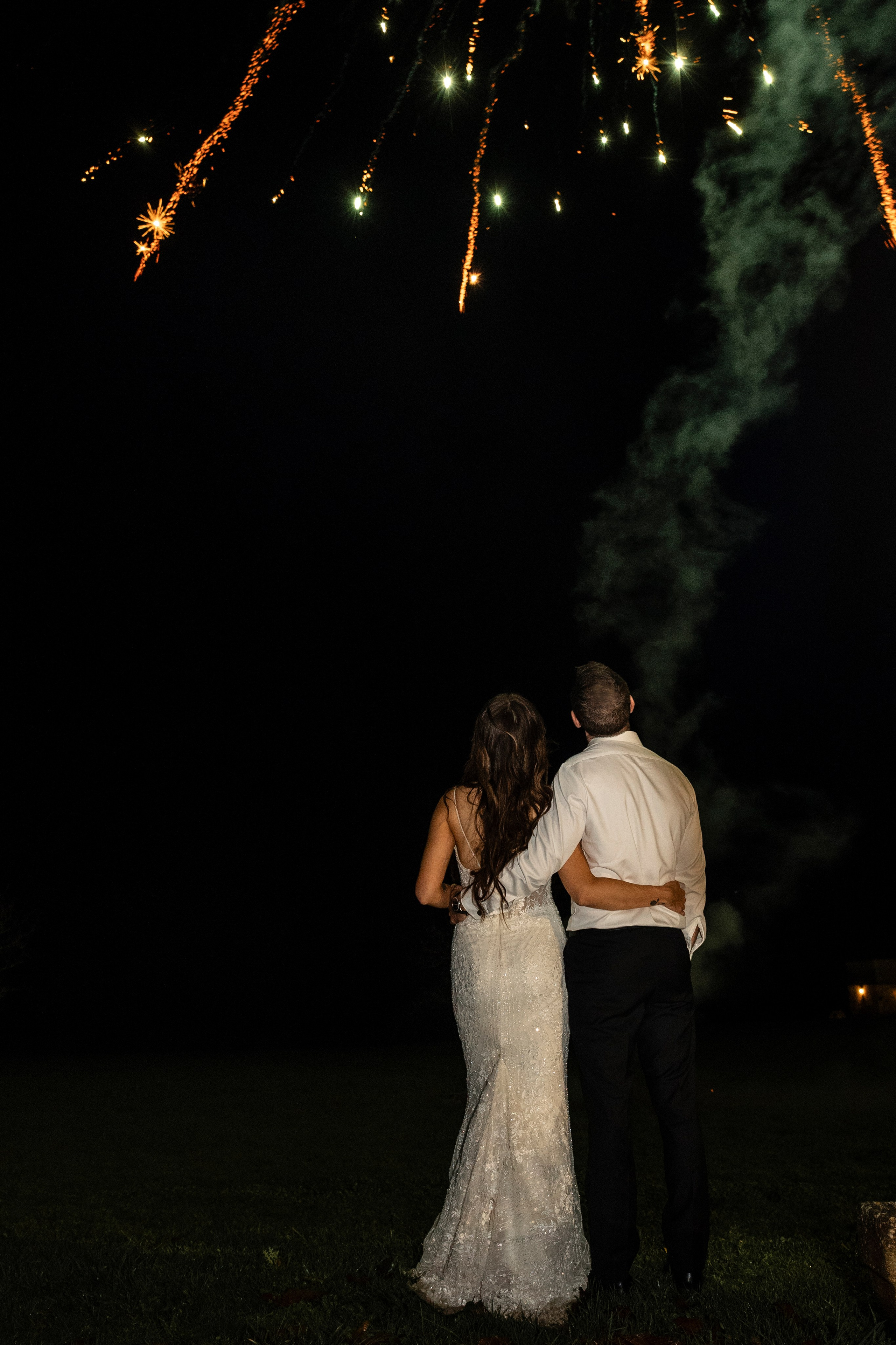 Bride and groom watching fireworks in the courtyard of Château Lagut, Dordogne.