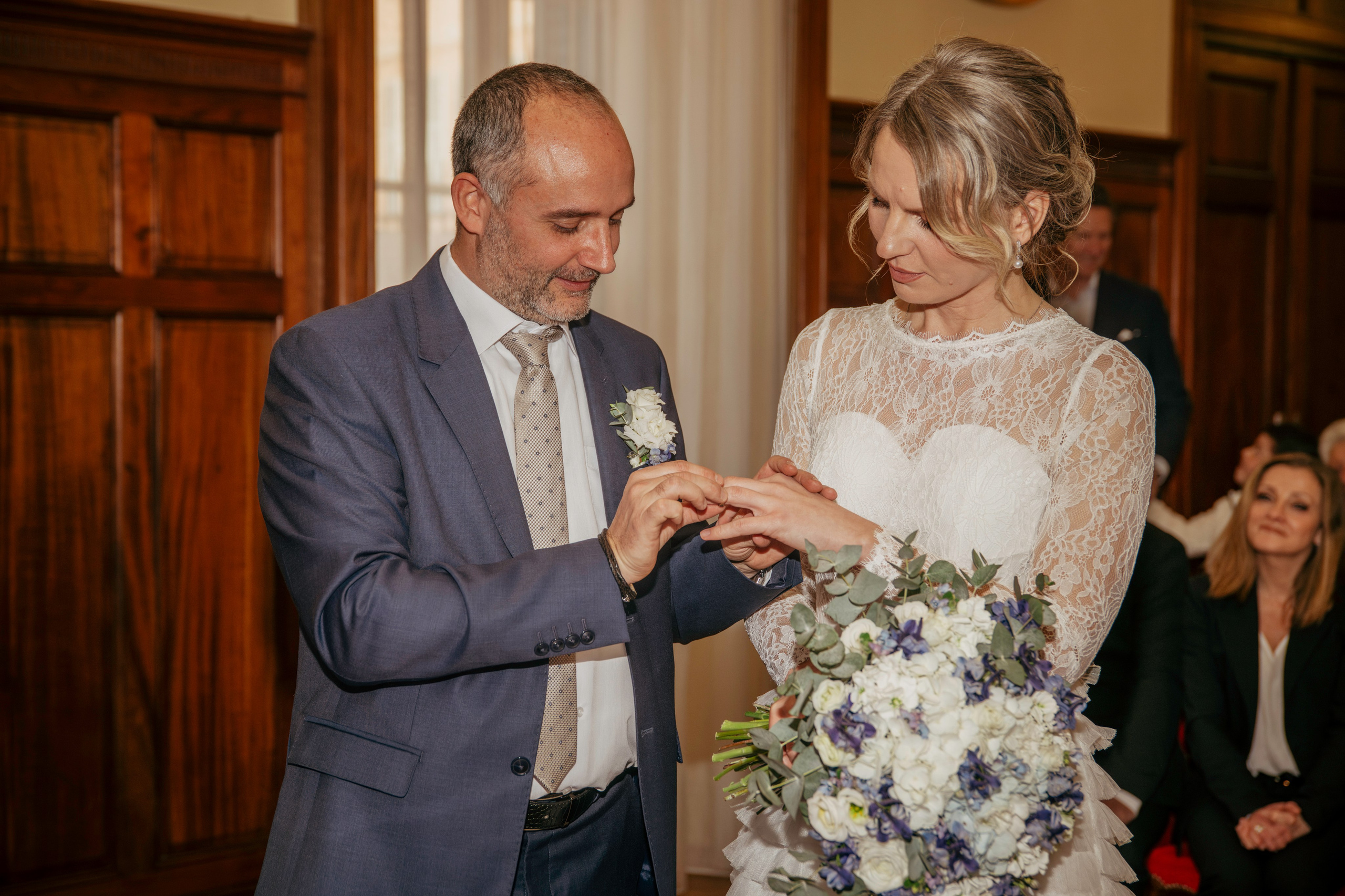 Жених надевает обручальное кольцо невесте на палец.