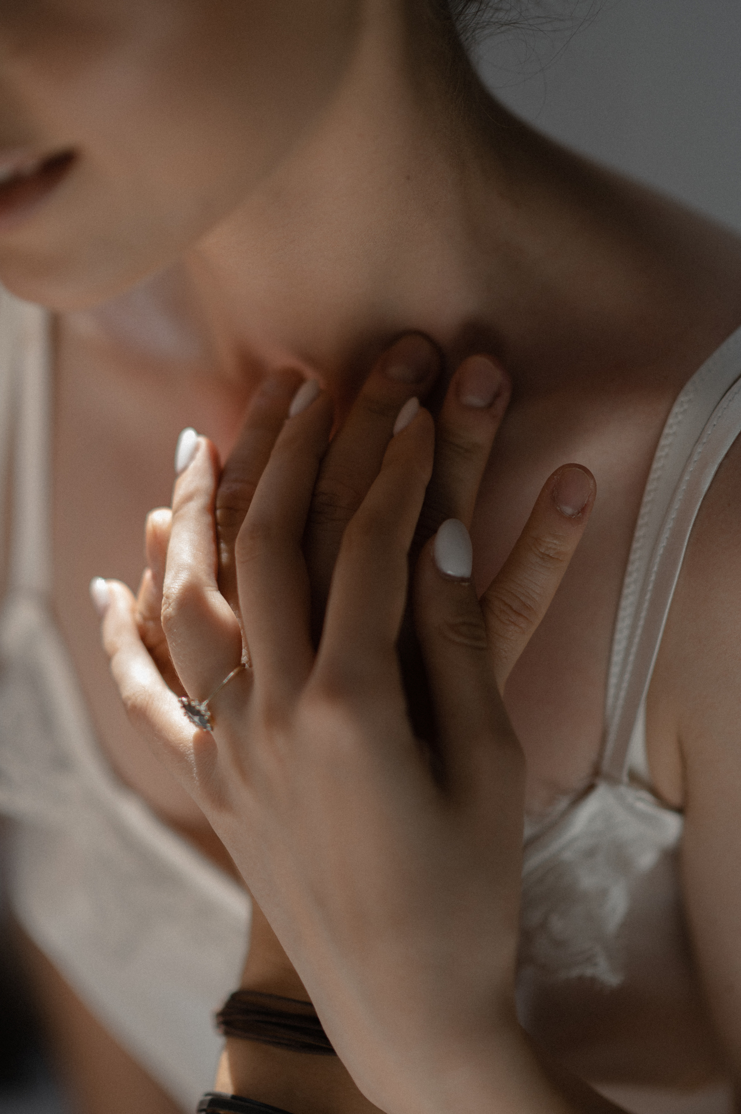 The photographer captures the couple's passionate kiss, focusing on their hands entwined, their tender touch and attention to details revealing the intensity of their connection in the room.