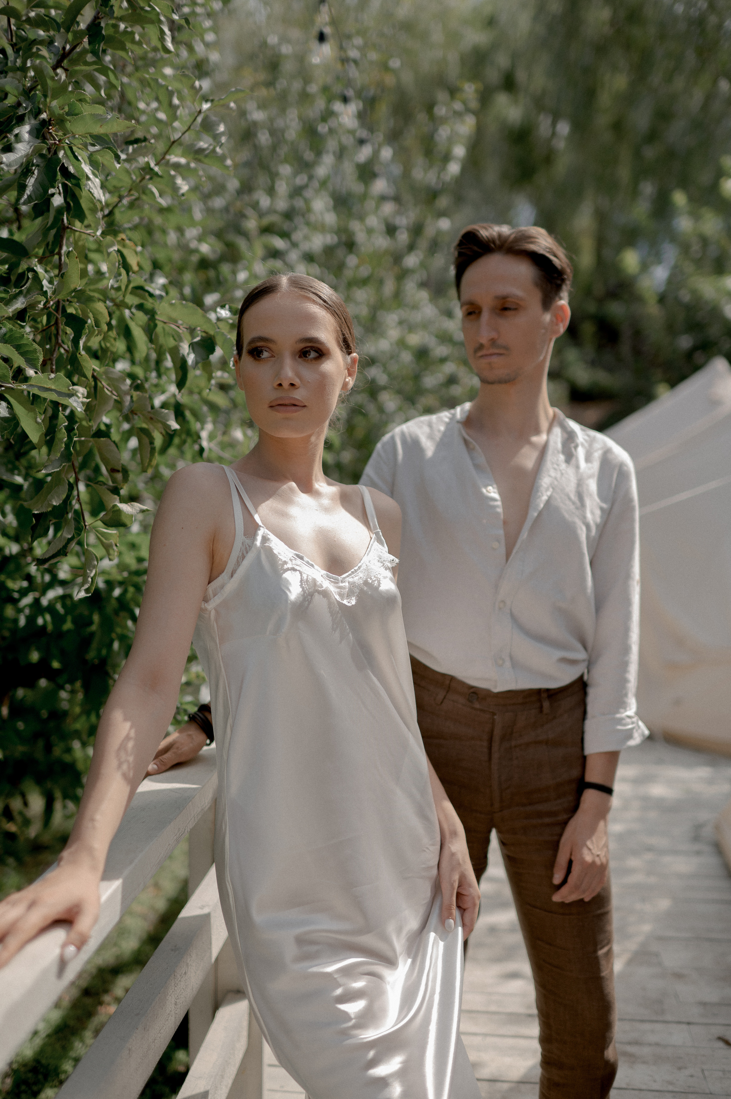 Amidst the tranquility of a secluded garden sanctuary, the couple's wedding morning is enriched by the comfort of glamping tents, allowing for loving and tender exchanges.