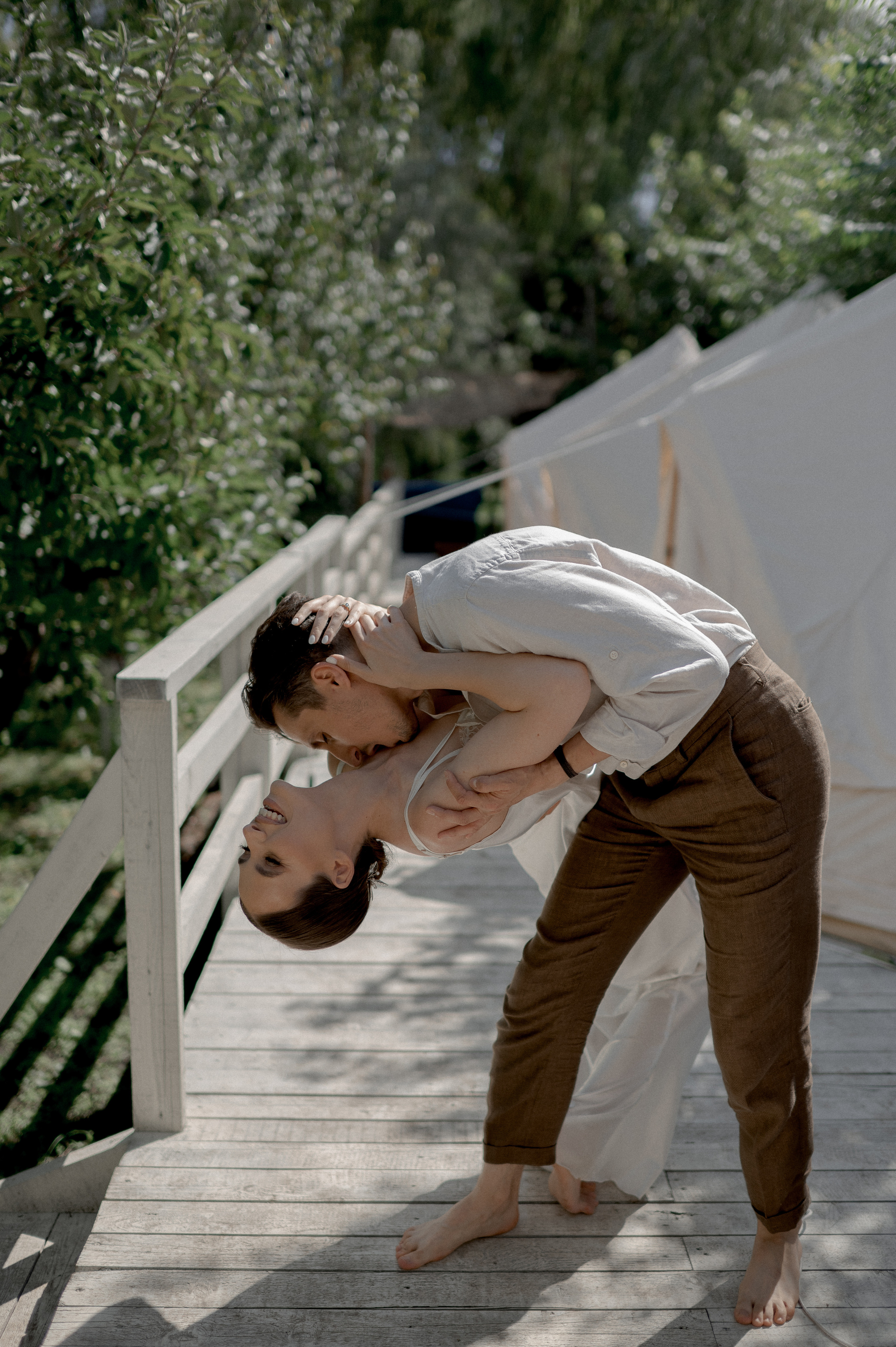 The couple's wedding morning is transformed into a magical experience in a secluded garden, where glamping tents provide a private and intimate setting for their loving and tender moments.