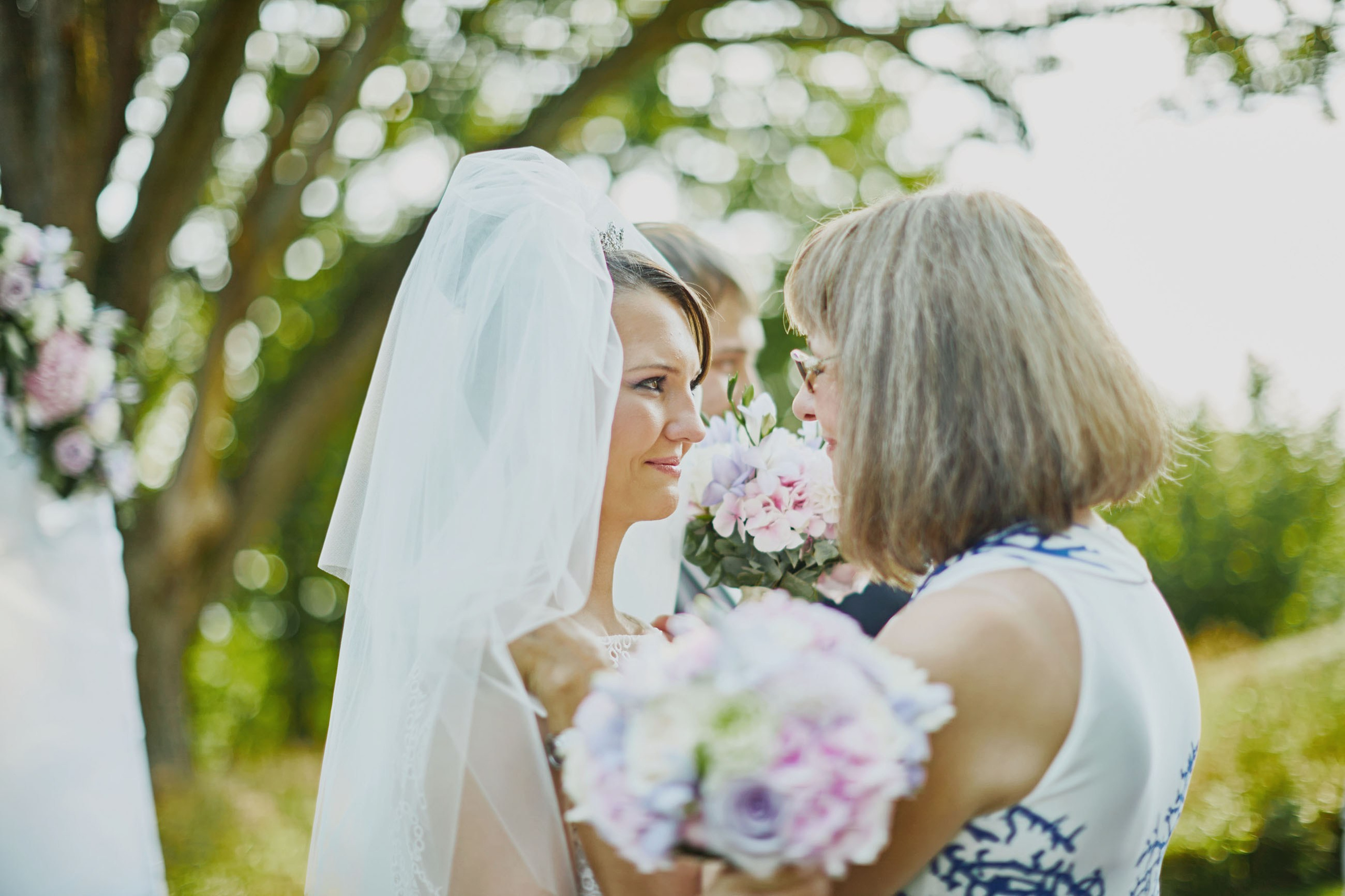 Mother tearfully congratulating bride after chateau wedding.