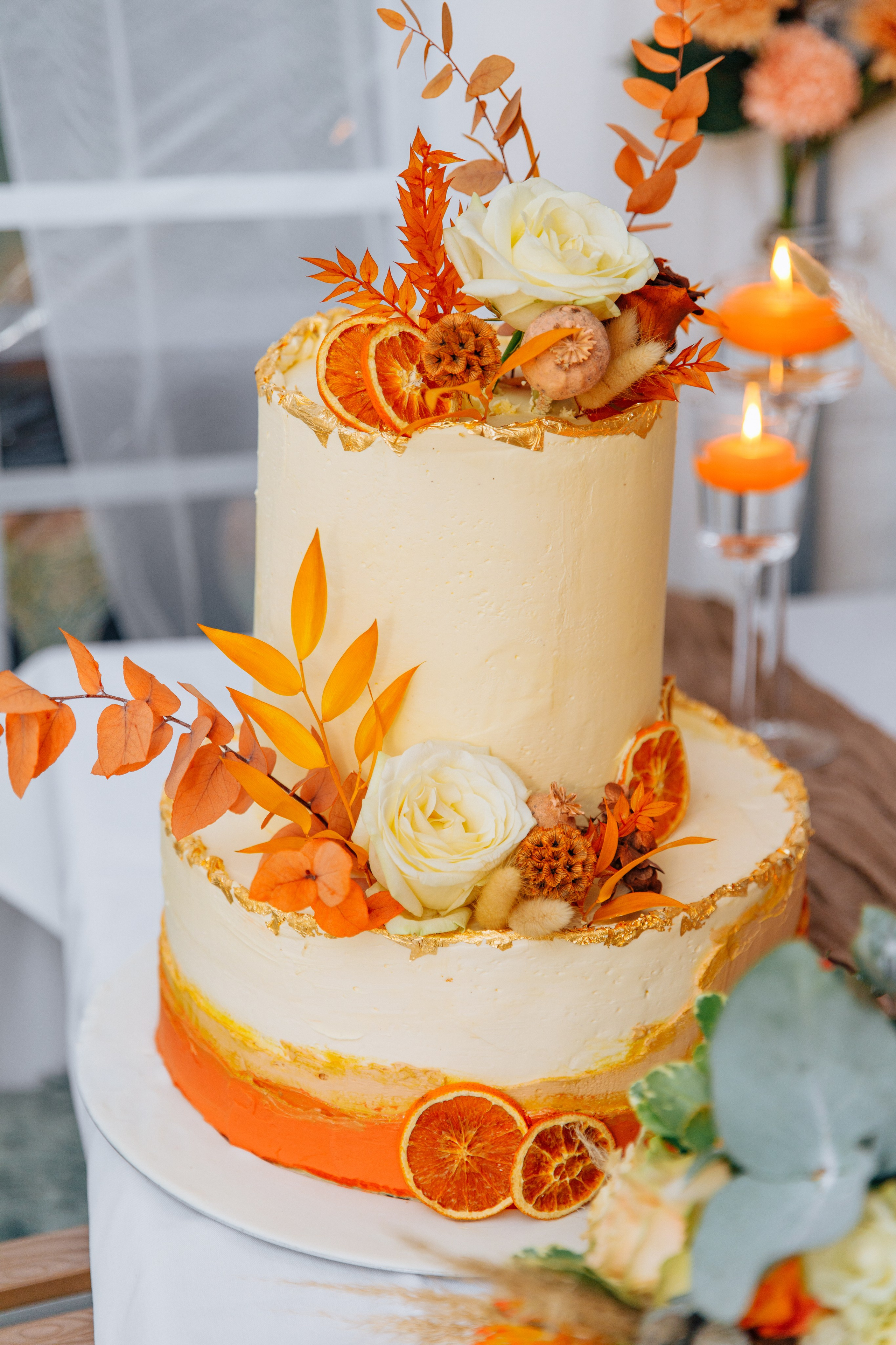 Hochzeitstorte für eine Herbsthochzeit in Orangetönen mit frischen Blumen.