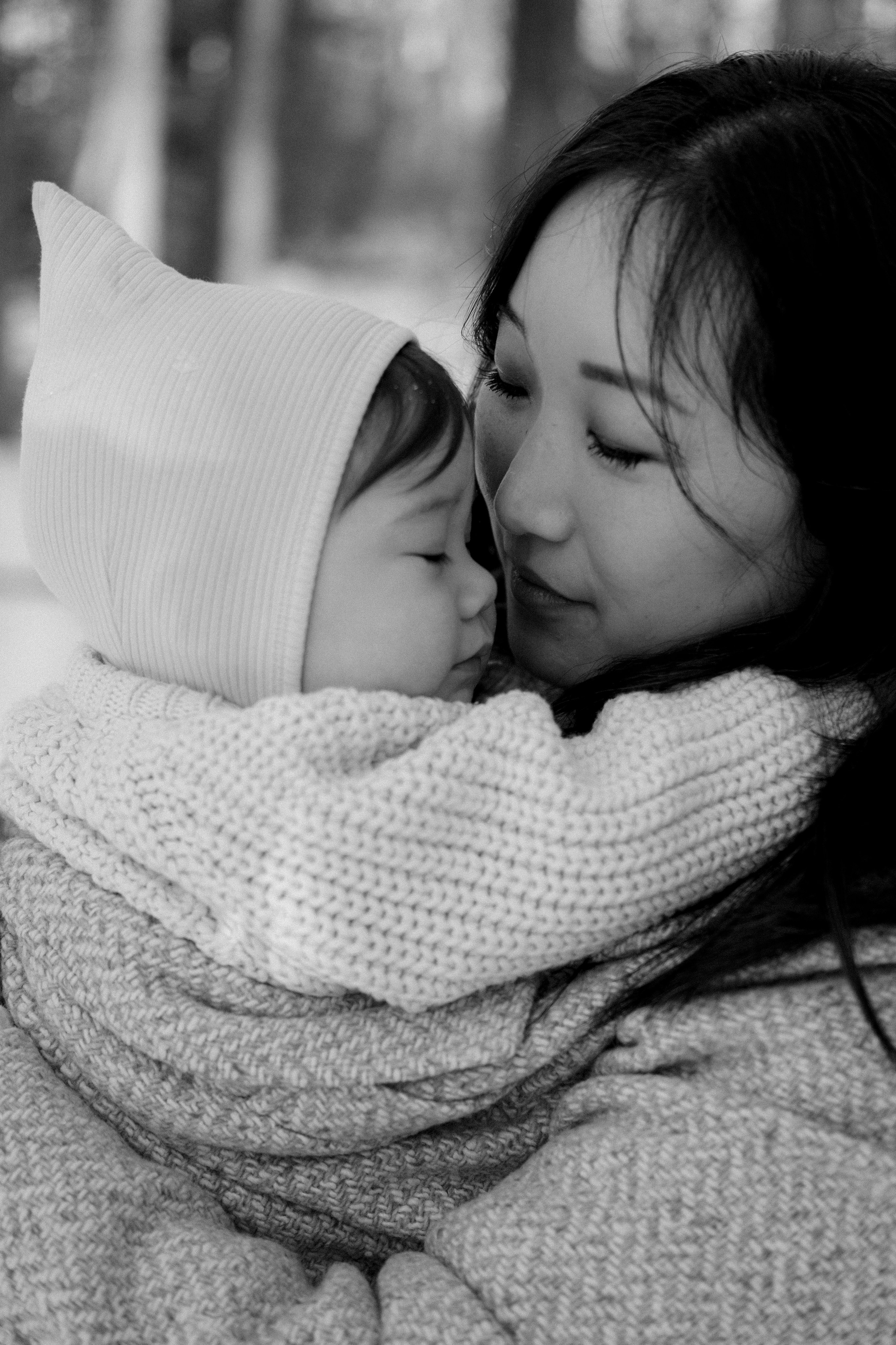 Mom hugging her baby daughter in a snowy backyard in Richmond, VA