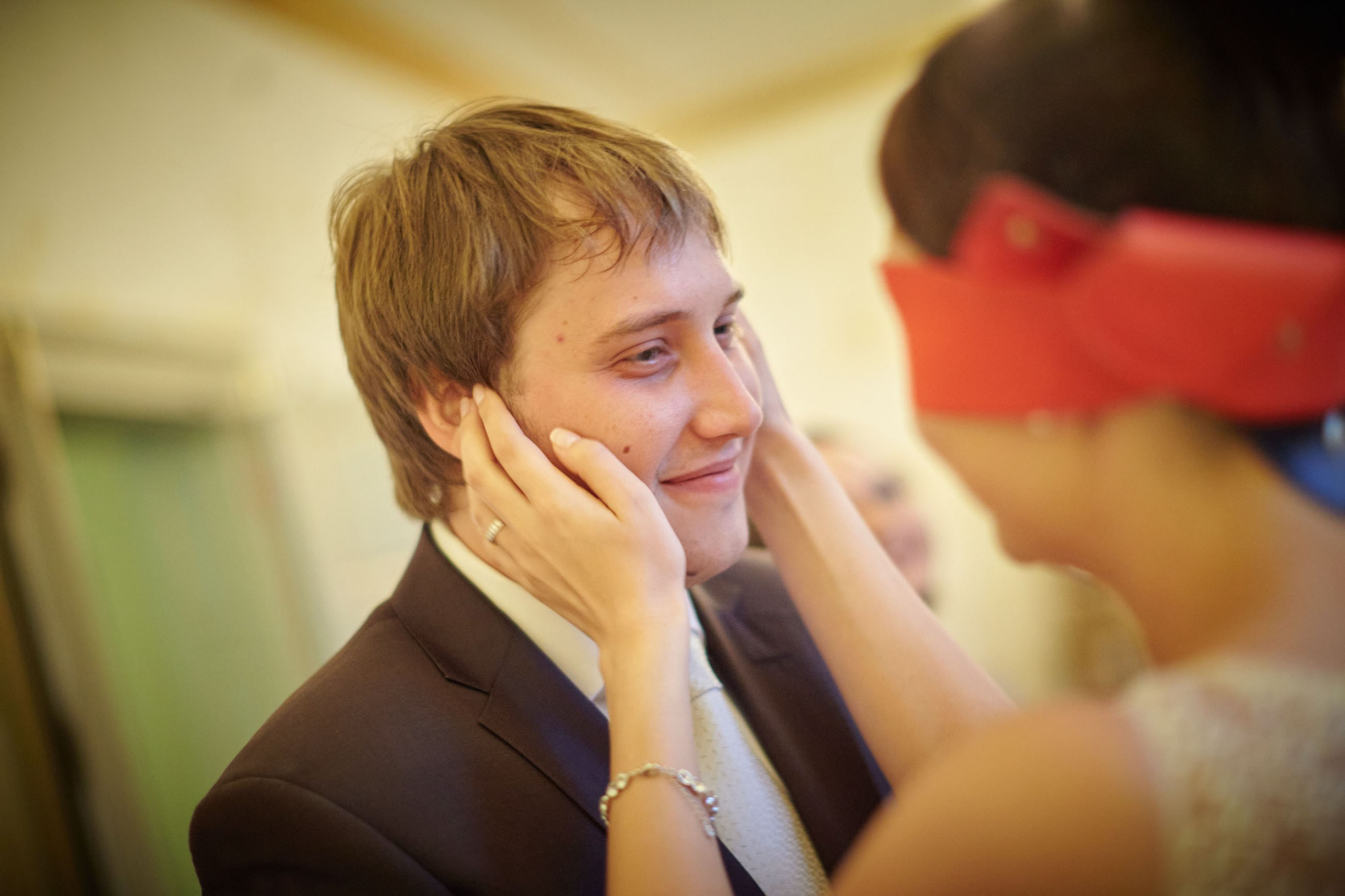 A blindfolded bride pauses as she believes she has located her groom by relying solely on touch in a playful wedding game.