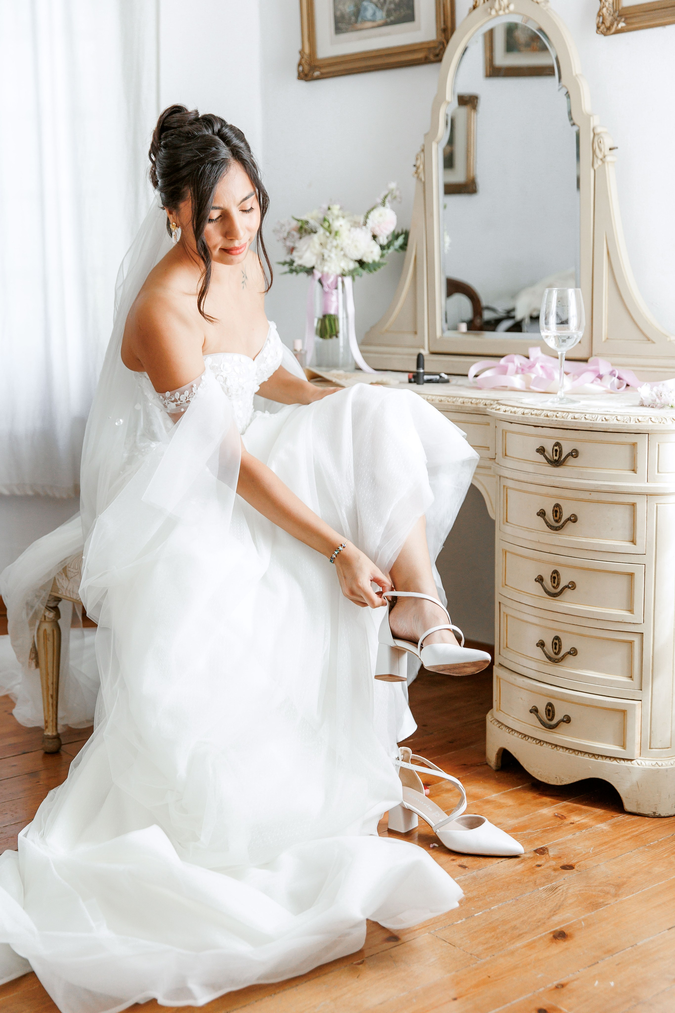 The bride wears stylish wedding shoes and expresses her excitement before the ceremony starts.